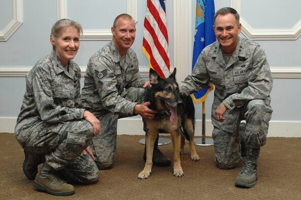 From the left, Col. Jeannie Leavitt, 4th Fighter Wing commander, Staff Sgt. Benjamin Seekell, 4th Security Forces Squadron military working dog trainer, Charlie, 4th SFS MWD and Maj. Gen. Jake Polumbo, 9th Air Force commander, pose for a group photo during Charlie’s retirement at Seymour Johnson Air Force Base, N.C., Aug. 23, 2013. Charlie retired after 10 years of dedicated service, including seven deployments and receiving the Purple Heart for injuries received in Afghanistan.  (U.S. Air Force photo by Airman 1st Class Brittain Crolley)