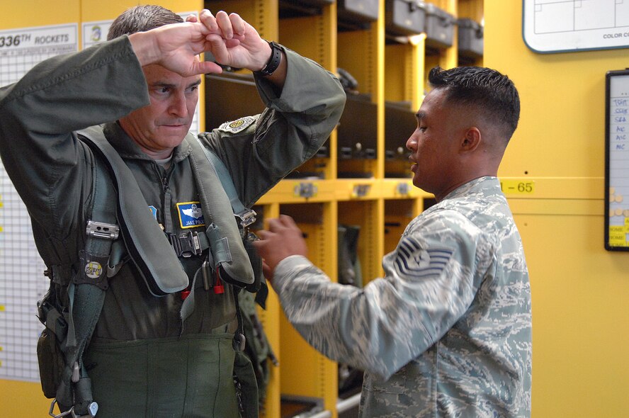 U.S. Air Force Tech. Sgt. Mark Natividad, 336th Fighter Squadron aircrew flight equipment NCO in charge (right), fits Maj. Gen. Jake Polumbo, 9th Air Force commander, with life support equipment before his flight in an F-15E Strike Eagle at Seymour Johnson Air Force Base, N.C., Aug. 22, 2013. Polumbo was able to interact with 4th Fighter Wing Airmen as they did their jobs. (U.S. Air Force photo by Airman 1st Class Brittain Crolley)