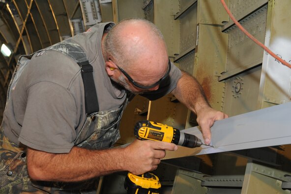 LeeRoy Smith, 902nd Mission Support Group Trainer Development Division sheet metal mechanic and painter, attaches parts to the interior of what will be a C-17 Aeromedical Trainer Aug. 19 at Joint Base San Antonio-Randolph.  (U.S. Air Force photo by Rich McFadden/released)