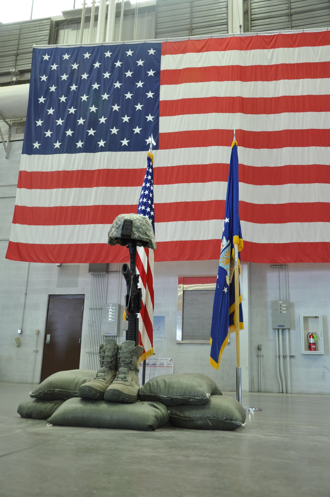 130906-F-CP693-010 During a memorial service held for Senior Airman Michael Gnoato Sept. 6, 2013, in the Peacekeeper High Bay, Bldg 1501, F.E. Warren Air Force Base, Wyo., a battle cross is placed between the U.S. and the Air Force flags. Gnoato was assigned to the 90th Missile Security Forces Squadron. (U.S. Air Force photo by 1st Lt. Eydie Sakura)  