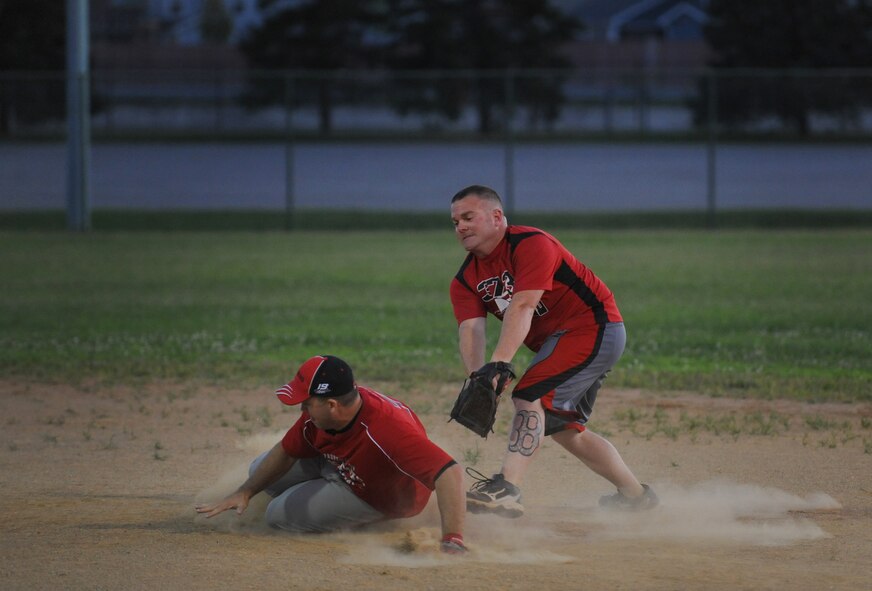 Mike Small, 436th Aircraft Maintenance Squadron, slides into second base after hitting a double while John Haggerty, 373rd Training Squadron/Maintenance Operations Squadron attempts to apply the tag during the championship game Sept. 4, 2013, at the softball field on Dover Air Force Base, Del. Small went 4-for-4 with three home runs, a double and nine RBI in game two to lead the 436th AMXS to the title. (U.S. Air Force photo/Staff Sgt. Elizabeth Morris)
