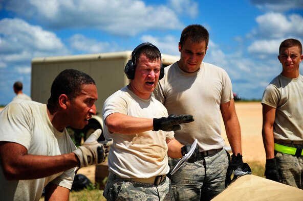 Lt. Col. Scott Lew, 570th Global Mobility Squadron director of operations, guides Airmen assigned to the 621st Contingency Response Wing, Travis Air Force Base, Calif., as they tear down their air mobility forward support base on Geronimo Landing Zone at Fort Polk, La. at the end of their Joint Readiness Training Center rotation 13-09, Aug. 24, 2013. The CRW specializes in rapidly establishing air mobility support operations in disaster-stricken, austere or hostile environments in response to natural disasters or combat operations. (U.S. Air Force photo/Tech. Sgt. Parker Gyokeres)