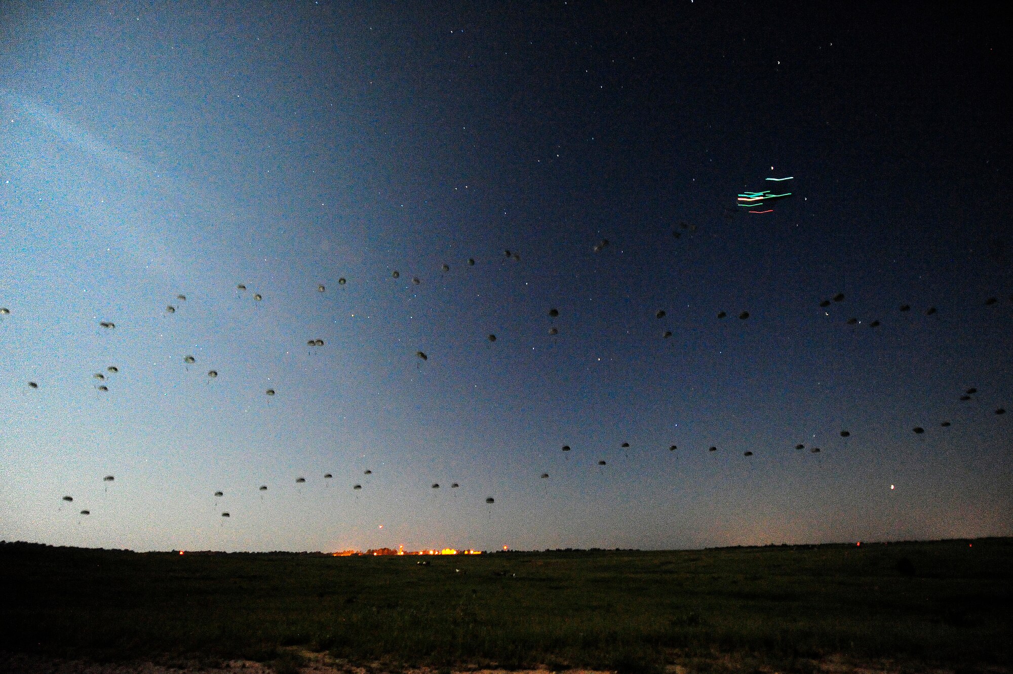 FORT POLK, La. – U.S. Army paratroopers assigned to the 3rd Brigade, 82nd Airborne Division from Fort Bragg, N.C., descend in the darkness onto the Geronimo Drop Zone at Fort Polk as part of a mass airdrop that began the combat phase of Joint Readiness Training Center rotation 13-09, Aug. 18, 2013. The Soldiers were responsible for taking and holding the airfield on Geronimo so aircraft could begin delivering heavy supplies and equipment.  (U.S. Air Force photo by Tech. Sgt. Parker Gyokeres)(Released)