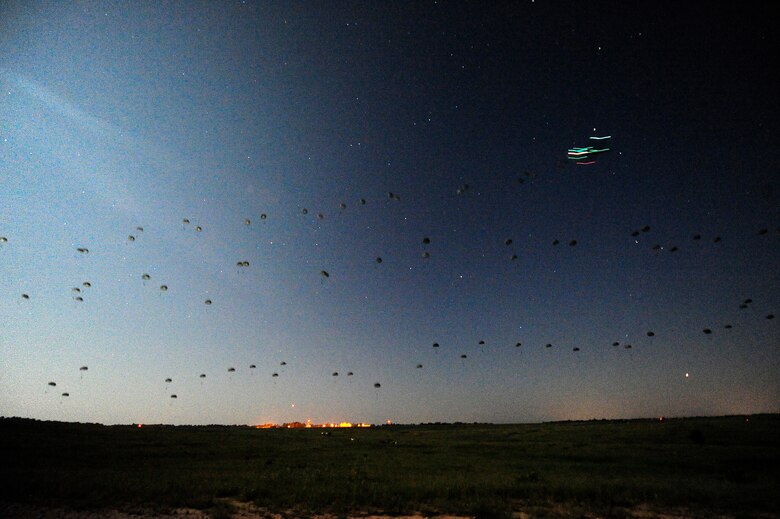FORT POLK, La. – U.S. Army paratroopers assigned to the 3rd Brigade, 82nd Airborne Division from Fort Bragg, N.C., descend in the darkness onto the Geronimo Drop Zone at Fort Polk as part of a mass airdrop that began the combat phase of Joint Readiness Training Center rotation 13-09, Aug. 18, 2013. The Soldiers were responsible for taking and holding the airfield on Geronimo so aircraft could begin delivering heavy supplies and equipment.  (U.S. Air Force photo by Tech. Sgt. Parker Gyokeres)(Released)
