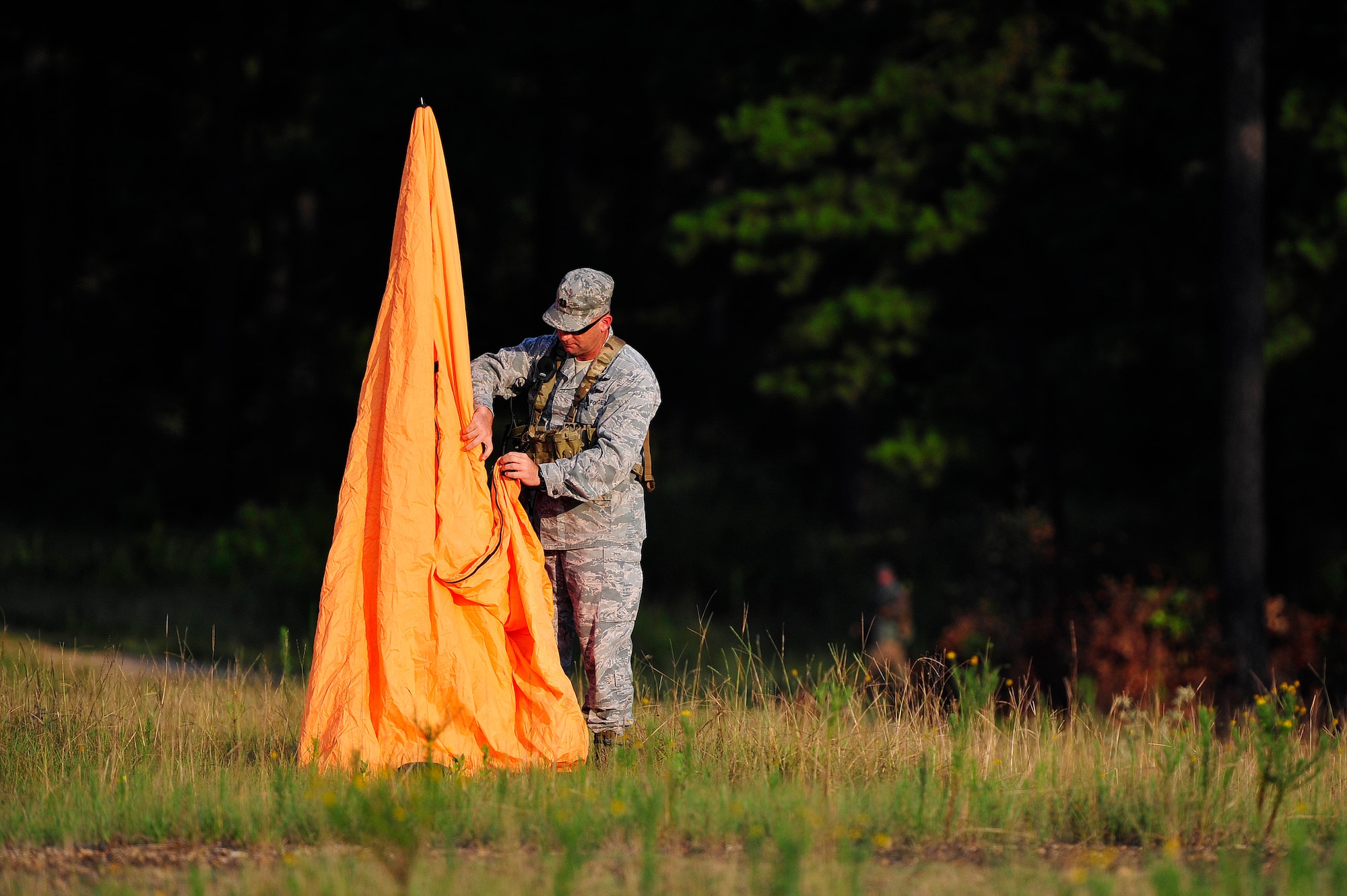 FORT POLK, La.-- U.S. Air Force Major Mike Welch, an air mobility liaison officer from the 621st Contingency Response Wing assigned to the U.S. Army’s 1st Theatre Sustainment Command at Fort Bragg, N.C., sets up a marker for a waiting C-130 Hercules circling over the ‘Strike’ Drop Zone at Fort Polk, La., Aug. 17, 2013 during Joint Readiness Training Center rotation 13-09. Air Mobility Command AMLOs are rated pilots or navigators assigned to U.S. Army and Marine units who coordinate with their joint and coalition partners for air mobility services provided by the U.S Air Force.  (U.S. Air Force photo by Tech. Sgt. Parker Gyokeres)(Released)