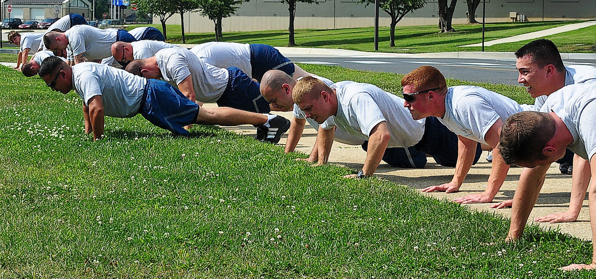 Airman Leadership School students preform push-ups during physical training Aug. 22, 2013, at the ALS building on Dover Air Force Base, Del. The students train three times a week to remain fit to fight. (U.S. Air Force photo/Airman 1st Class Ashlin Federick)