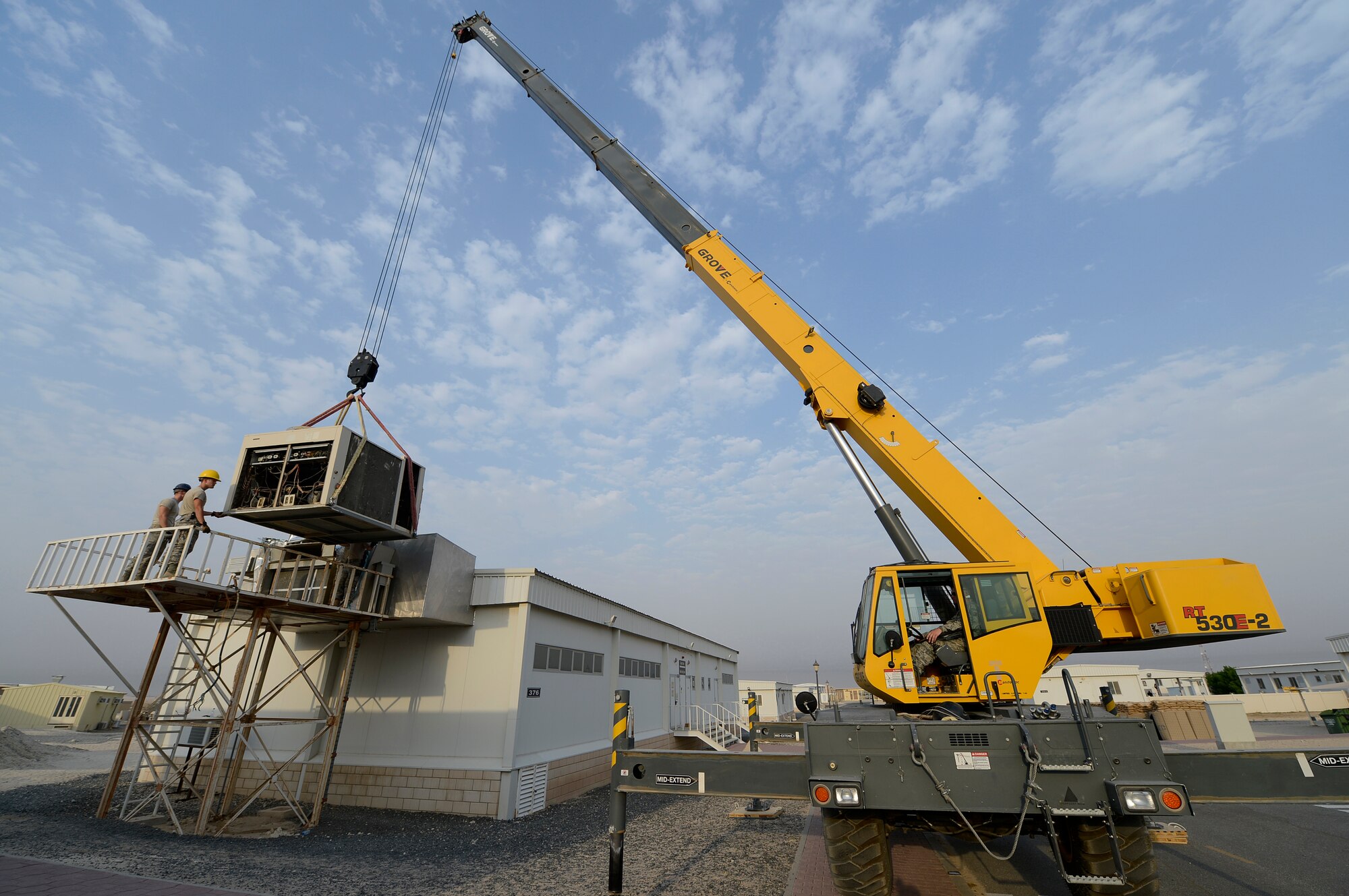 Members of the 386th Expeditionary Civil Engineer Squadron remove a malfunctioning air conditioner here, Sept. 6, 2013.  The unit was a 25-ton, 2-stage air conditioner package unit which supplied heat and air conditioning to the base education center. (U.S. Air Force photo by Master Sgt. Christopher A. Campbell)