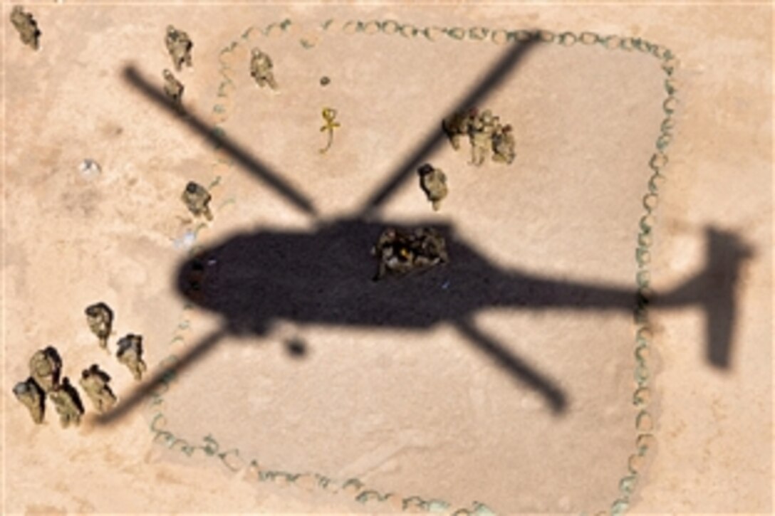 U.S. troops prepare for a UH-60 Black Hawk helicopter to hoist them up during hoist training on Forward Operating Base Farah, Afghanistan, Sept. 8, 2013. The troops are assigned to the 758th Forward Surgical Team, Provincial Reconstruction Team Farah, and the helicopter crew is assigned to Company C, 1st Battalion, 168th Aviation Regiment, General Support Aviation Battalion.