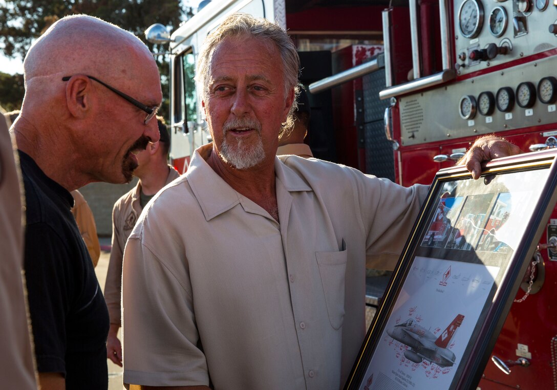 Dave Largent, left, a mechanic with Rancho Auto Body and an Encinitas, Calif., native, and Jimmy Gillan, right, owner of Rancho Auto Body, and an Encinitas, Calif., native, look at the plaque given to them by the commanding officer of Marine Fighter Attack Squadron 232 for helping them complete the Fighter Truck, VMFA-232’s squadron vehicle, during a sendoff for VMFA-232 and Marine Fighter Attack Squadron (All Weather) 225 at the Officers’ Club aboard Marine Corps Air Station Miramar, Calif., Sep. 6. 
