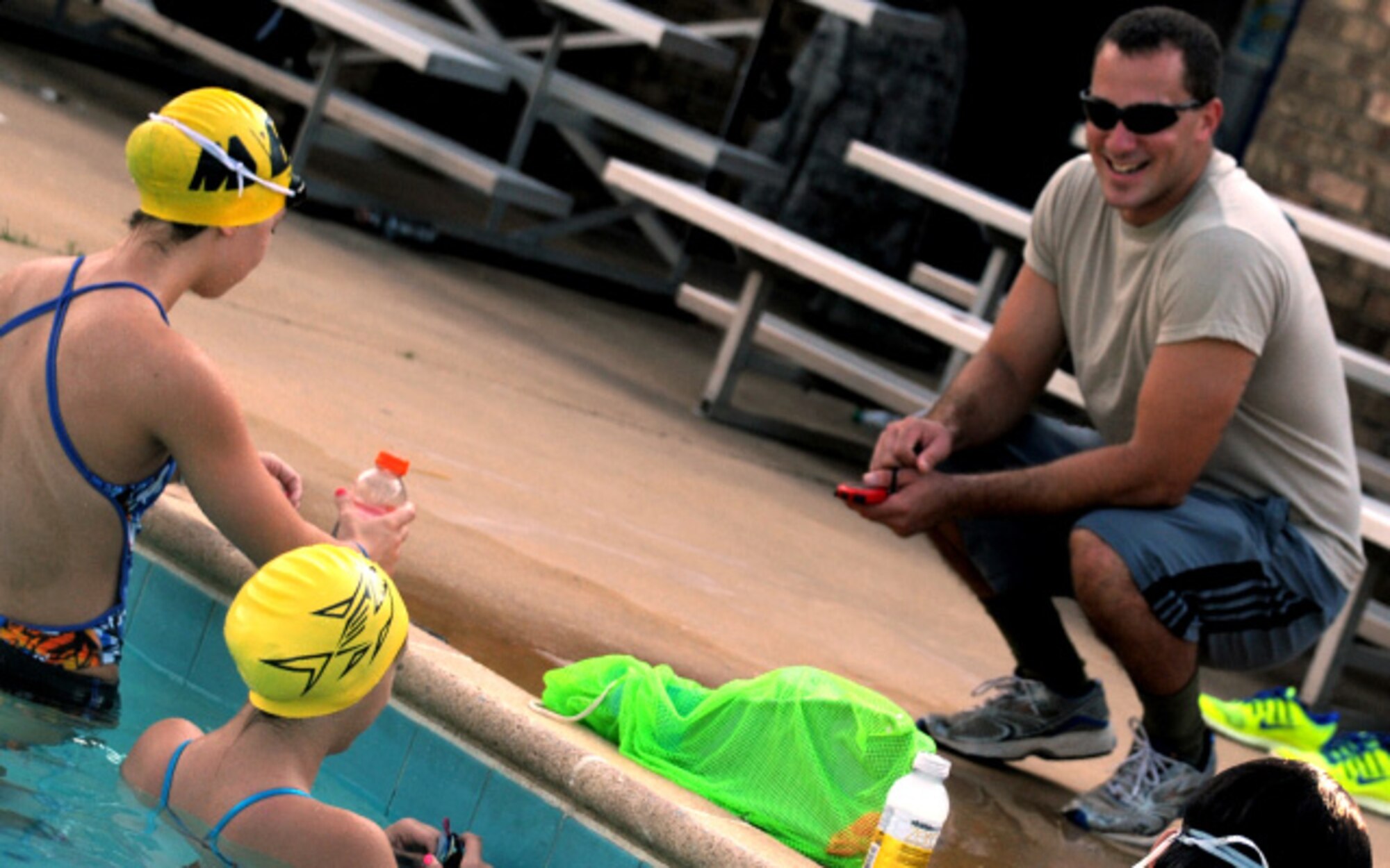 Airman 1st Class Lance Thornton coaches members of his team at practice Aug. 30. Thornton began volunteering and sharing his experience from competing at the college level in the 100-yard butterfly, 100-yard breaststroke, 50-yard freestyle, and 200-yard individual medley which he set the school record in 2009.