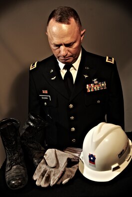 U.S. Army National Guard Chief Warrant Officer 4 Clifford Bauman reflects Aug. 22, 2013, on the boots, gloves and hat he wore during search and rescue missions at the Pentagon, Washington, D.C., after the Sept. 11, 2001 attacks. After the missions were over, Bauman placed the work gear in closet and did not touch them again until 12 years later. (U.S. Air Force photo illustration/Staff Sgt. Jarad A. Denton)