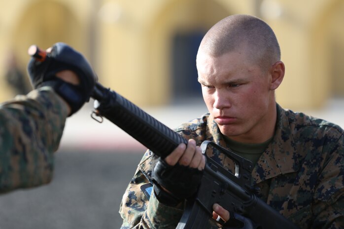 Recruit Cody Carter, Platoon 3271, Company M, 3rd Recruit Training Battalion, executes a counter to the muzzle grab during the Marine Corps Martial Arts Program test aboard Marine Corps Recruit Depot San Diego, Aug. 21. If a recruit fails to perform a technique properly after two attempts an “X” is marked on his scorecard.