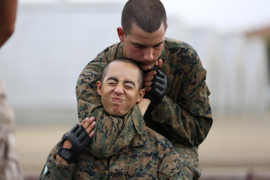 Recruit Tyler A. Rowe, Platoon 3271, Company M, 3rd Recruit Training Battalion, executes a rear choke on his fellow recruit, Carlos Garcia, during the Marine Corps Martial Arts Program test aboard Marine Corps Recruit Depot San Diego, Aug. 21.  Upon successful completion of the test, recruits will earn the first belt level of MCMAP, the tan belt.