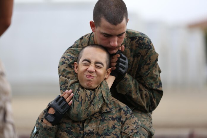Recruit Tyler A. Rowe, Platoon 3271, Company M, 3rd Recruit Training Battalion, executes a rear choke on his fellow recruit, Carlos Garcia, during the Marine Corps Martial Arts Program test aboard Marine Corps Recruit Depot San Diego, Aug. 21.  Upon successful completion of the test, recruits will earn the first belt level of MCMAP, the tan belt.