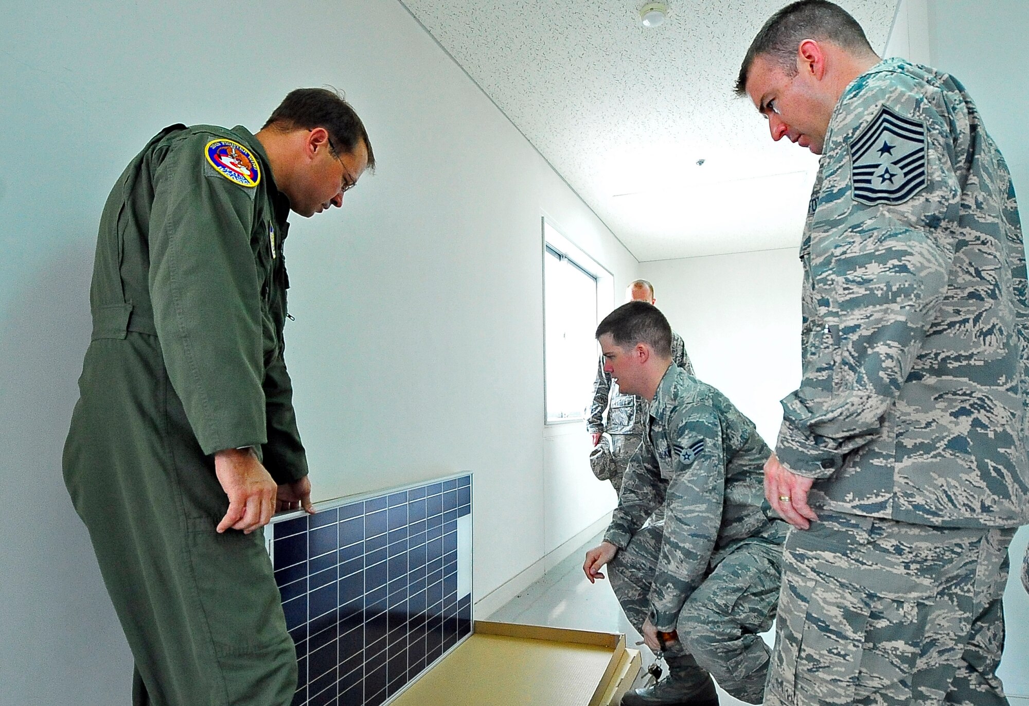 U.S. Air Force Senior Airman Christofer Floyd, 35th Communications Squadron transmission systems technician, shows Col. Stephen Williams, 35th Fighter Wing commander, and Chief Master Sgt. Gary Sharp, 35 FW command chief, a solar panel during a visit to a tower at Misawa Air Base, Japan, Aug. 16, 2013. Solar panels are being installed across the base on every giant voice system to ensure notifications are received in the event of a real world emergency. Approximately 60 solar panels are scheduled to be up and running by spring 2014 as a backup power source for the giant voice. (U.S. Air Force photo by Staff Sgt. Nathan Lipscomb)