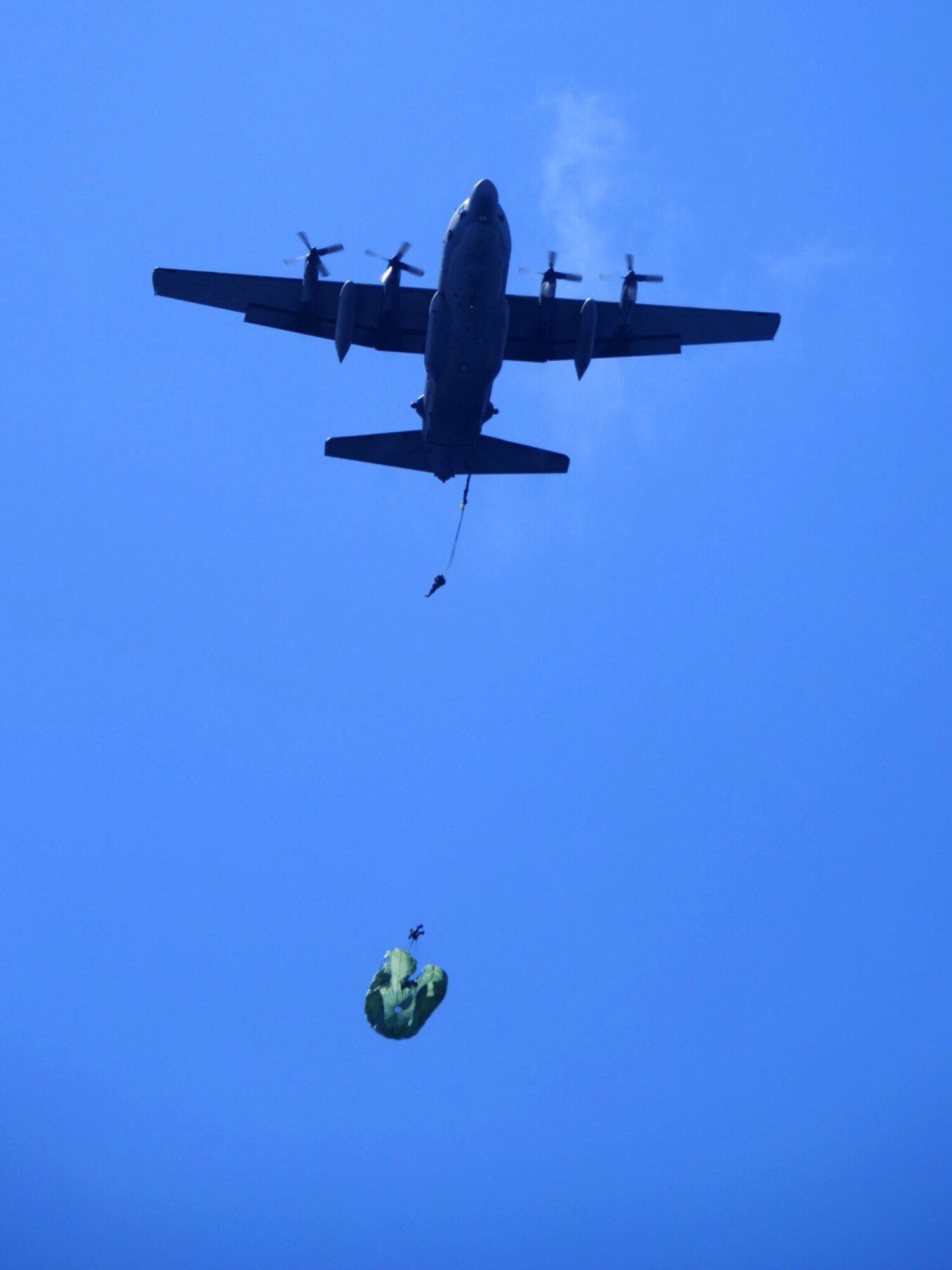 Airmen from the 320th Special Tactics Squadron exit an MC-130H Combat Talon II operated by the 1st Special Operations Squadron on August 28, 2013 during static line jump training off the coast of White Beach Naval Facility, Okinawa.  The STS Airmen conducted water landings as part of a quarterly training requirement to ensure they remain current and proficient in both static line and free fall jumps. (U.S. Air Force photo by Tech. Sgt. Kristine Dreyer) 