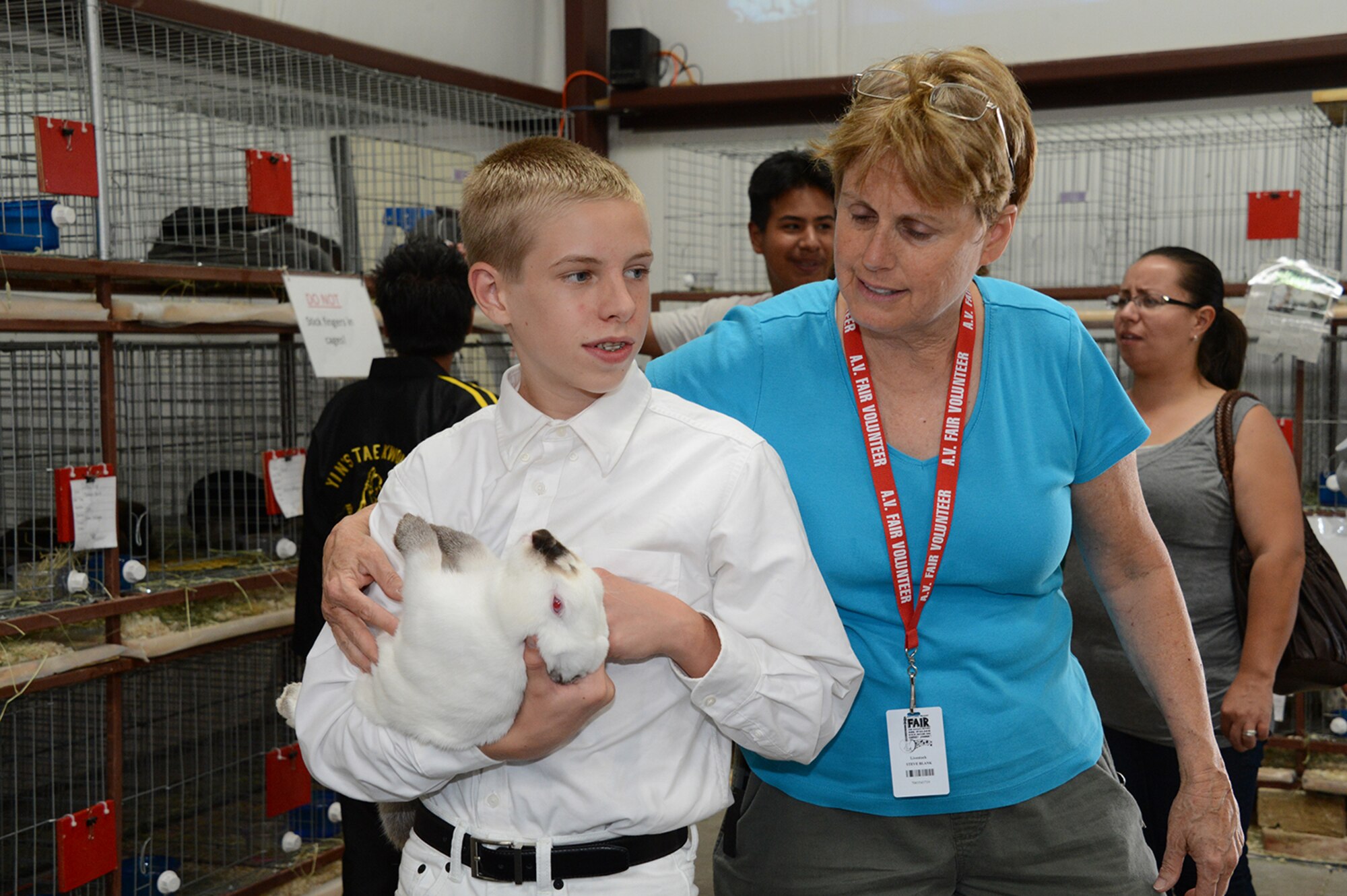 Young Michael Kasperson handles a rabbit with the guidance of Laura Blank, Air Force Test Center management analyst. Blank volunteers her time to teach children about breeding and raising rabbits. (Courtesy photo)