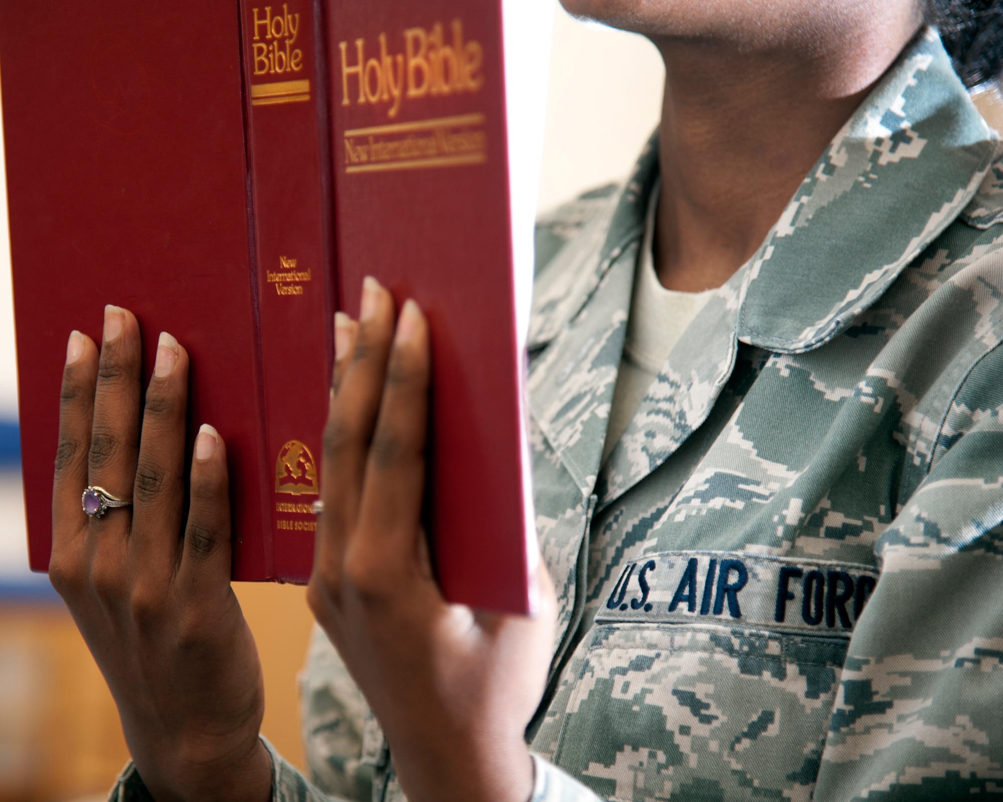 An Air Force senior airman reads the bible in a base chapel at an undisclosed location. The Airman is a rape survivor and said her faith has been extremely significant in coping and recovery. She’s a victim advocate in the base sexual assault prevention and response program.  (U.S. Air Force photo by Master Sgt. Kevin Wallace/RELEASED)