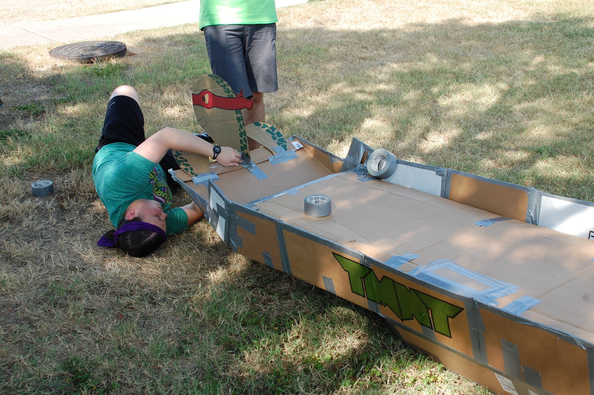 JOINT BASE SAN ANTONIO-LACKLAND, Texas – A student with the 59th Training Squadron’s Teenage Mutant Ninja Turtles team puts the finishing touches on their cardboard boat. (U.S. Air Force photo/Debbie Aragon)