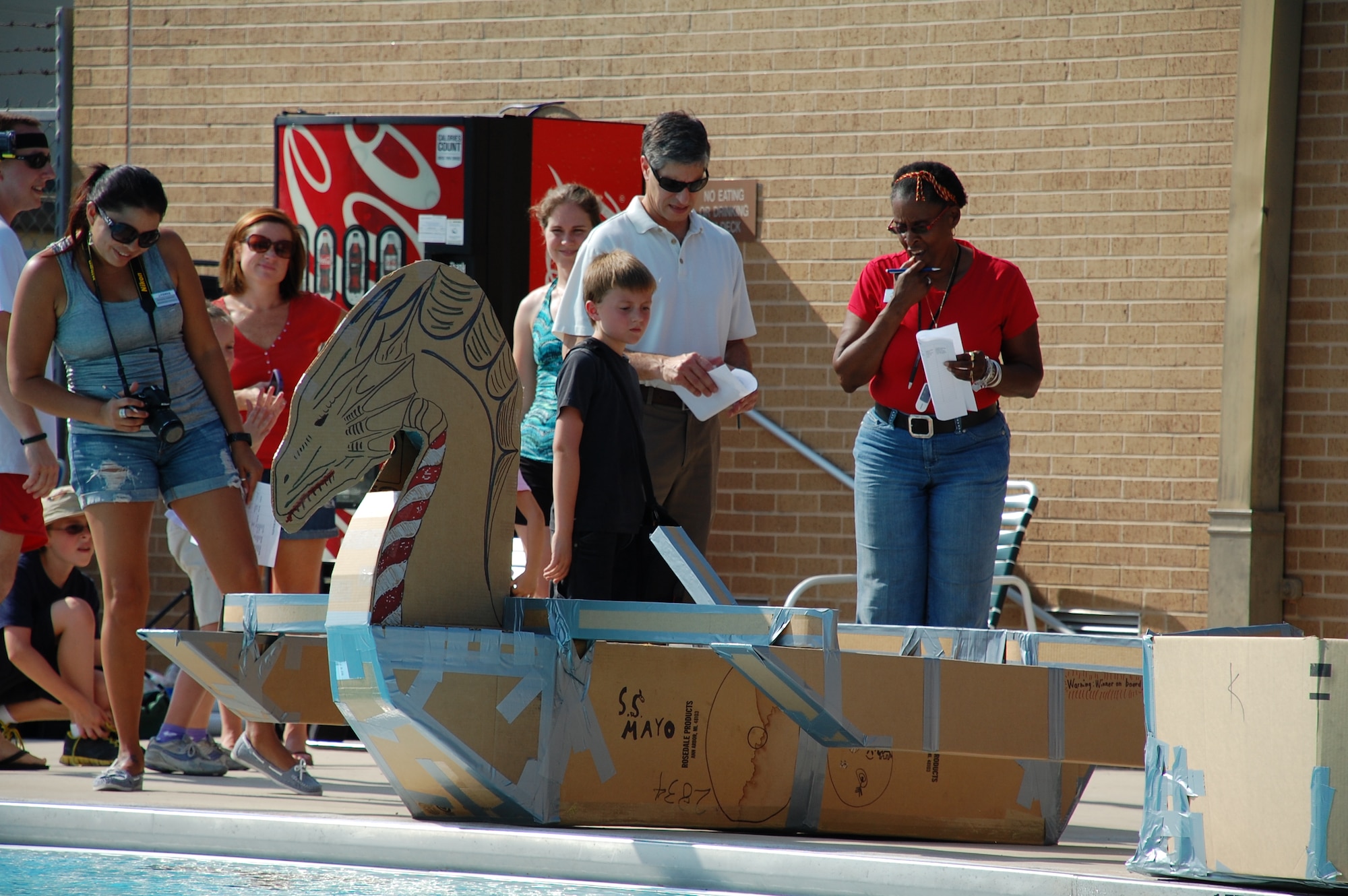 JOINT BASE SAN ANTONIO-LACKLAND, Texas – Susana Salazar, Brian Milkovich and Gloria Singleton inspect the S.S. Mayo before the race Sept. 6, 2013, to make sure it was built within the rules of engagement – made entirely with cardboard, not more than 10 feet long and with duct tape only covering seams, beams and joints. (U.S. Air Force photo/Debbie Aragon)