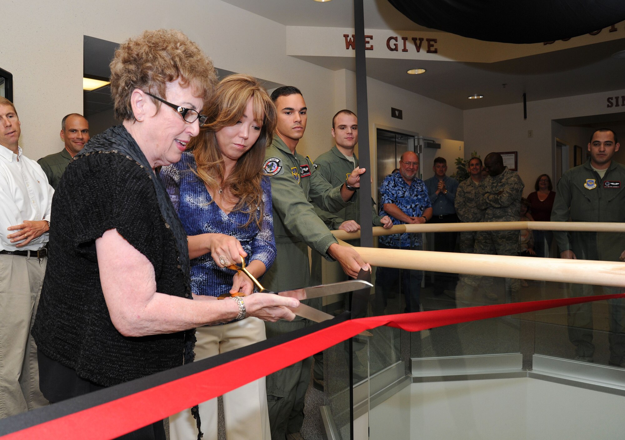 Mrs. Erica Leeds, wife of Lt. Col. Oliver Leeds, 92nd Air Refueling Squadron commander, and Mrs. Garnet Clay, wife of the 92nd ARS honorary commander Dennis Clay, cut the ribbon to unveil a model of a KB-29 aircraft during the renaming ceremony of the 92nd ARS auditorium at Fairchild Air Force Base, Wash., Sept 5, 2013. The 92nd ARS acknowledged the pioneering character of Col. Gerrald M. Vivian, the pilot to deliver the first KC-135 Stratotanker to Fairchild, along with a ribbon cutting of a heritage display. (U.S. Air Force photo by Airman 1st Class Janelle Patiño/Released)