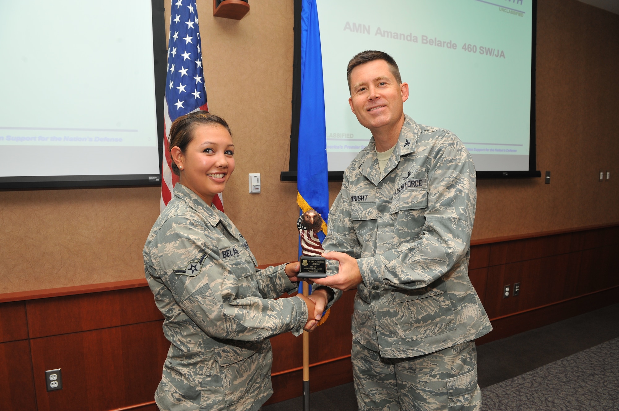 Airman Amanda L. Belarde, Buckley Legal Office military justice paralegal, receives the Airman of the Month Award from Col. Dan Wright, 460th Space Wing commander, Sept. 10, 2013, at Buckley Air Force Base, Colo. Belarde received this award for her exceptional service in courts-martial, successfully completing her Career Development Courses and her work as the Airman Against Drunk Driving vice president. (U.S. Air Force photo by Phillip Houk/Released)