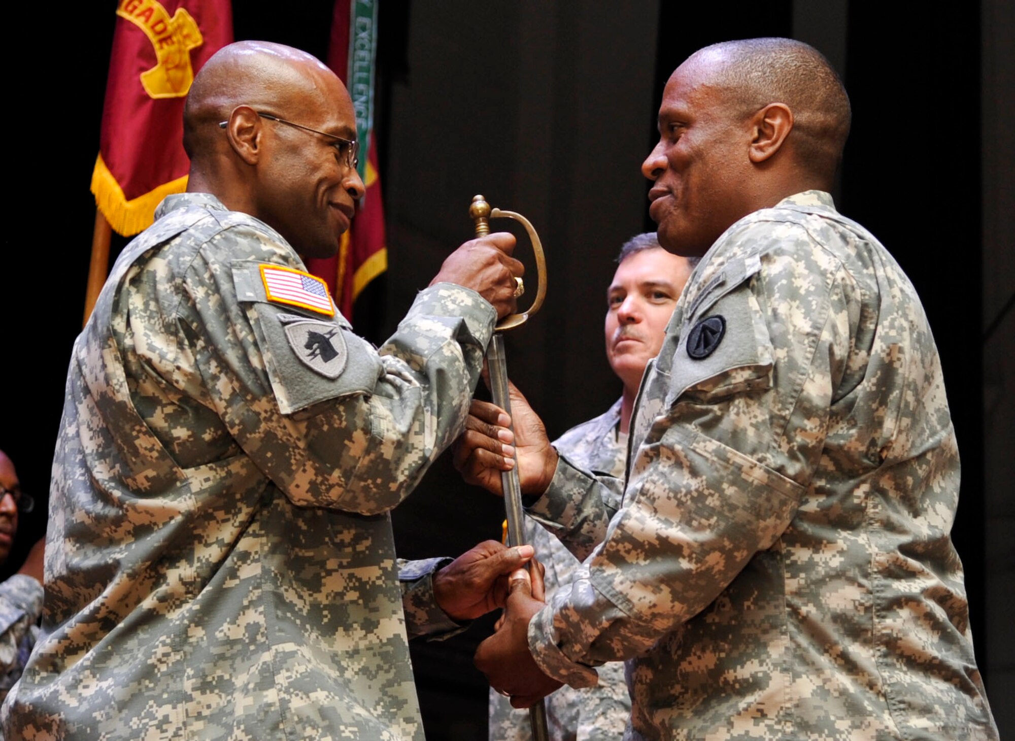 From left, U.S. Army Sgt. Maj. Alveno Hodge, incoming 597th Transportation Brigade 
command sergeant major, accepts the battalion noncommissioned officer sword from U.S. Army Col. Jason Vick, 597th Transportation Brigade commander, during the change of responsibility ceremony at Fort Eustis, Va., Sept. 10, 2013. Hodge assumed the role of command sergeant major from U.S. Army Sgt. Maj. Kenneth Blasko. (U.S. Air Force photo by Staff Sgt. Wesley Farnsworth/Released)