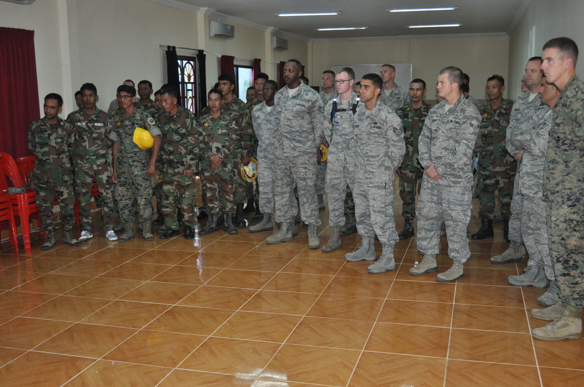 Royal Cambodia Air Forces and U.S. forces gather together Sept 8 for a safety briefing prior to beginning of Pacific Angel 13-5 Cambodia. Sixteen U.S. forces engineers will work alongside 20 Royal Cambodia Armed Forces engineers to renovate three health centers in Takeo. PACANGEL is a joint and combined humanitarian assistance operation held in various countries several times a year and includes medical, dental, optometry, and engineering support programs and various subject-matter expert exchanges. (U.S. Air Force photo/ Senior Master Sgt. Allison Day)