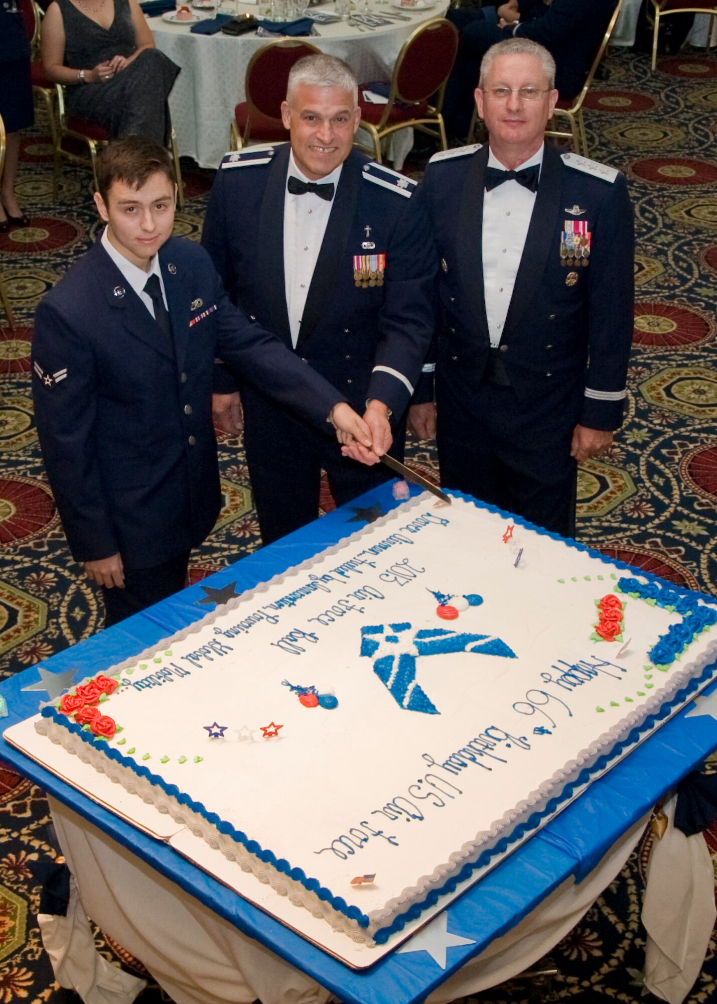 Team Dover’s youngest Airman, Airman 1st Class Darrion Guest, 736th Aircraft Maintenance Squadron, and oldest Airman, Chaplain (Lt. Col.) Dennis Saucier, 436th Airlift Wing, steady the knife before cutting the Air Force Birthday cake alongside Lt. Gen. Mark Ramsay, Joint Staff director of force structure, Sept. 6, 2013, at Dover Downs in Dover, Del. One tradition of the Air Force Ball is to have the youngest and oldest Airmen cut the cake. (U.S. Air Force photo/ Senior Airman Jared Duhon)