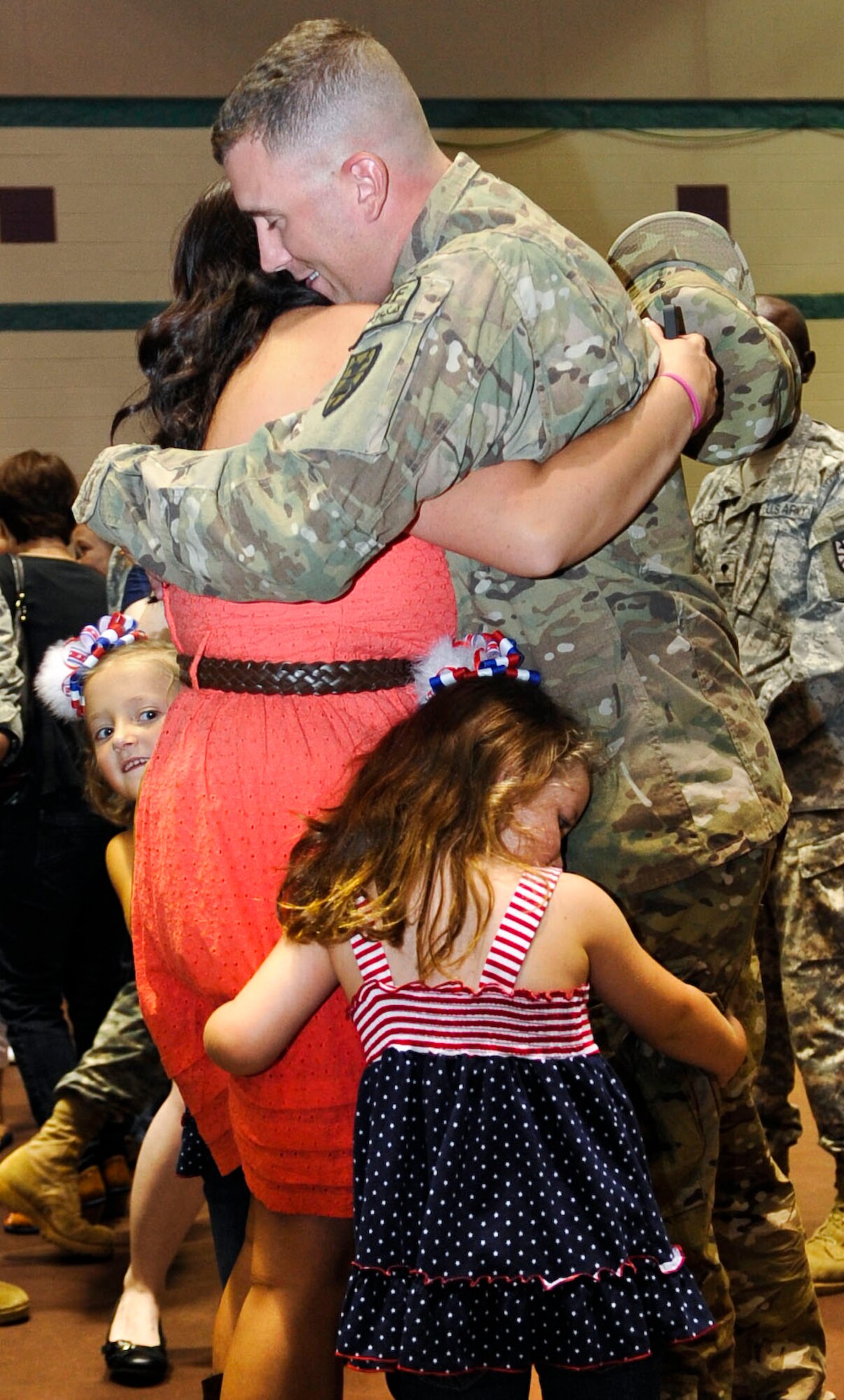 U.S. Army Spc. James Reed, a Soldier with the 359th Inland Cargo Transfer Company, hugs his wife Alisha and daughters Julianna and Brielle, during a welcome-home ceremony for the 359th Inland Cargo Transfer Company at Fort Eustis, Va., Sept. 9, 2013. The 359th ICTC recently completed a nine-month tour in Afghanistan. (U.S. Air Force photo by Staff Sgt. Wesley Farnsworth/Released)