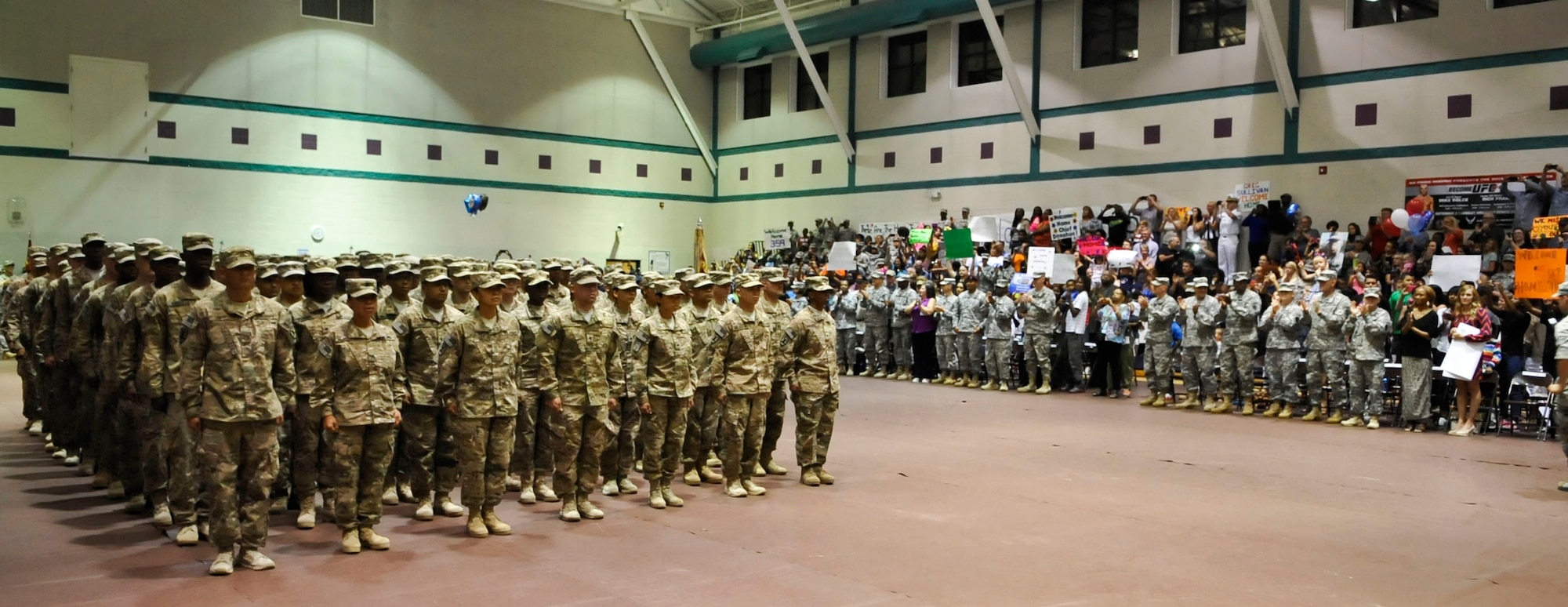 Family members cheer as members of the 359th Inland Cargo Transfer Company make their appearance at a welcome home-ceremony at Fort Eustis, Va., Sept. 9, 2013. The 359th ICTC completed a nine-month tour in Afghanistan where they conducted 62 missions across 480,000 miles, earned 17 Purple Hearts, 55 combat action badges and two battlefield promotions. (U.S. Air Force photo by Staff Sgt. Wesley Farnsworth/Released)