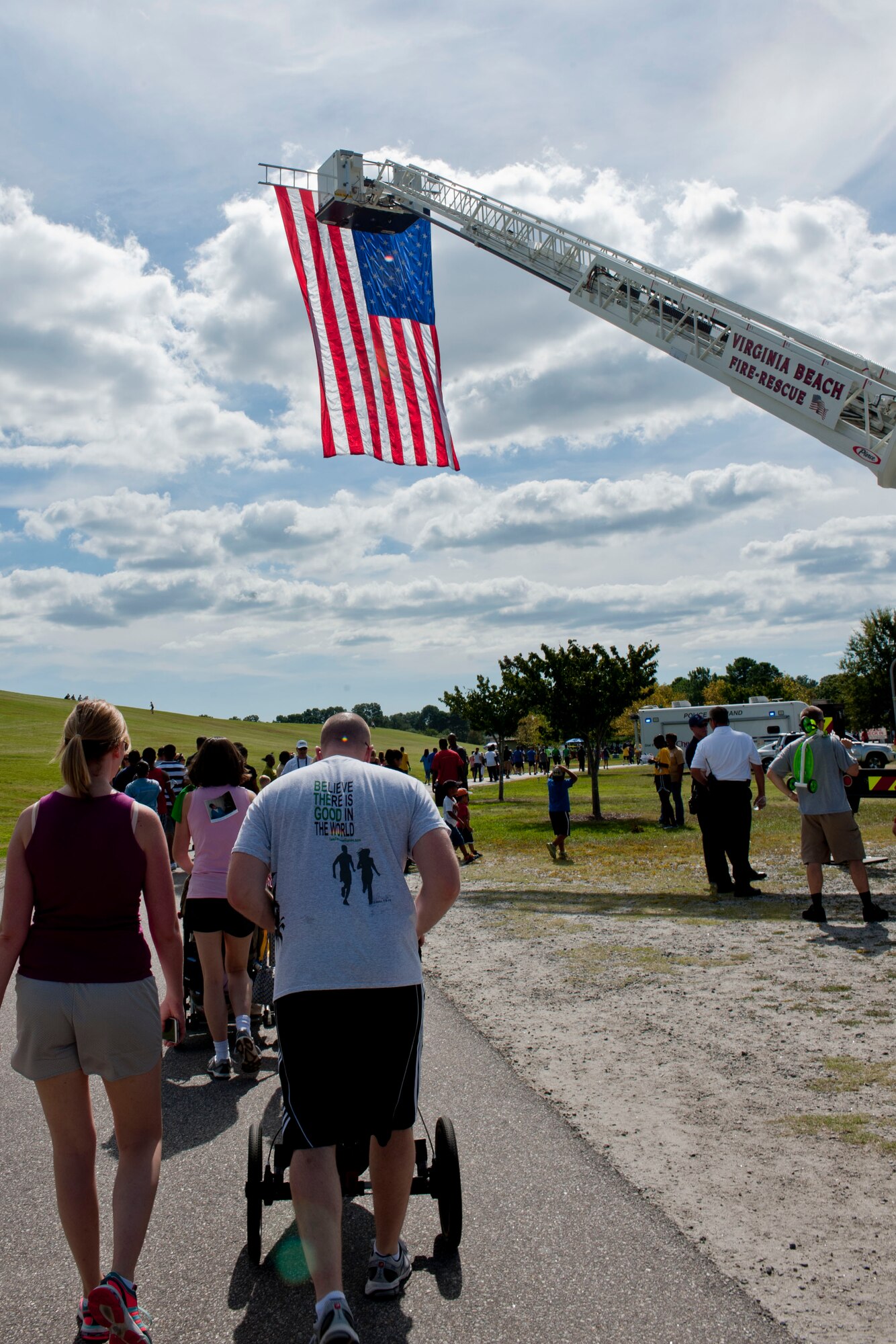 Members of the Virginia Beach fire department raise the American flag over participants during the Out of Darkness suicide awareness walk in Virginia Beach, Va., Sept. 7, 2013. More than 4,500 participants attended the walk to aid raise awareness about depression and suicide prevention.  (U.S. Air Force photo by Staff Sgt. Stephanie Rubi/Released)