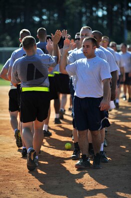 U.S. Army Soldiers and U.S. Air Force Airmen high-five each other after finishing a softball game against one another during the 20th Mission Support Group Warrior Challenge, Shaw Air Force Base, S.C., Sept. 6, 2013. The 20th MSG Warrior Challenge, a day-long event meant to boost morale between Airmen and Soldiers, included softball, tug of war, a watermelon eating contest and other events to build camaraderie.  (U.S. Air Force photo by Airman 1st Class Jensen Stidham/Released)