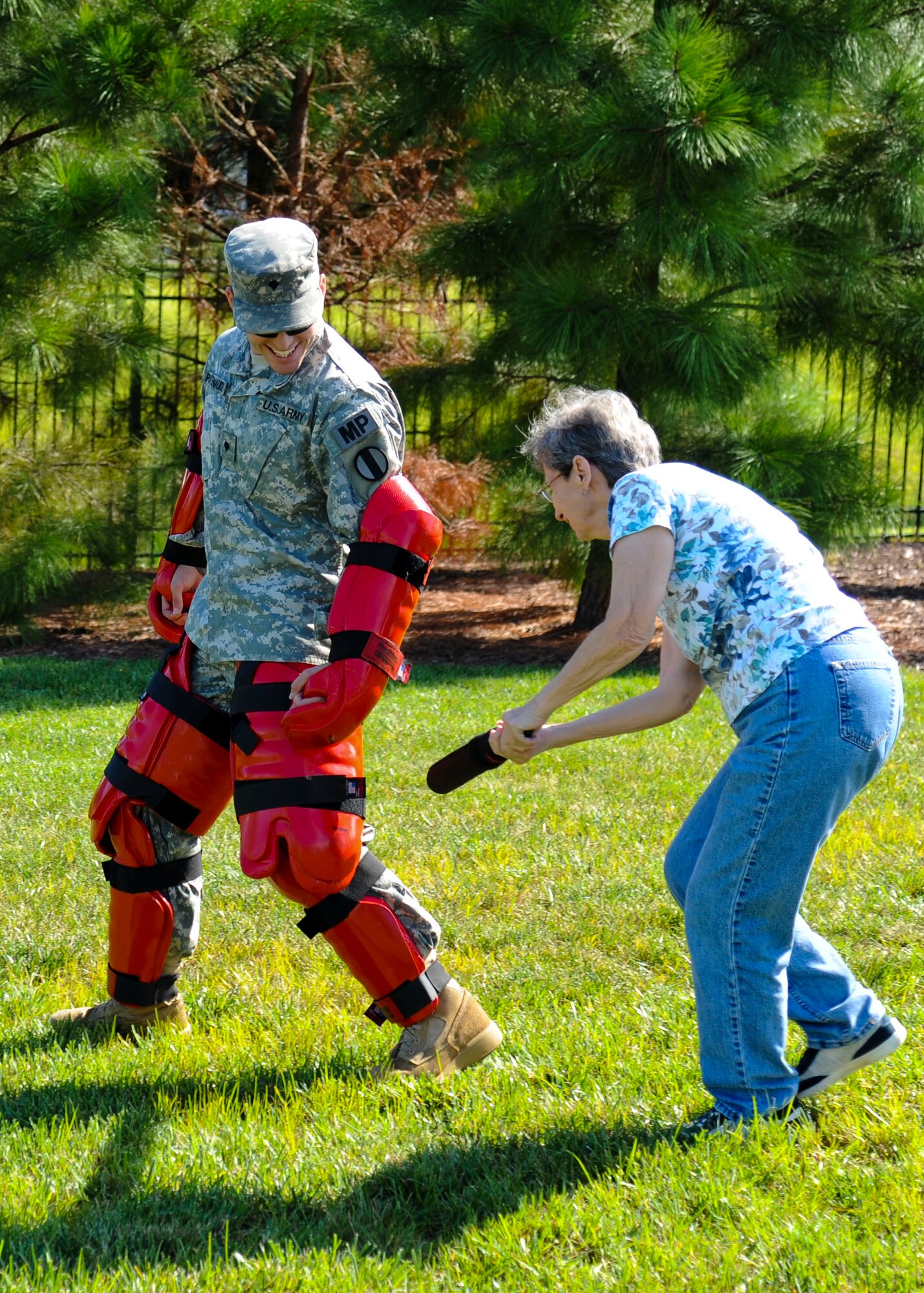 Candace Carter, a Community Day participant, swings at U.S. Army Spc. Richard Patenaude, 221st Military Police Detachment patrolman, Sept. 7, 2013, at Fort Eustis, Va. The 221st MP Det. and the 733rd Civil Engineer Division firefighters presented multiple activities for the community to educate them on fire safety and law enforcement duties. (U.S. Air Force photo by Airman 1st Class Austin Harvill/Released)