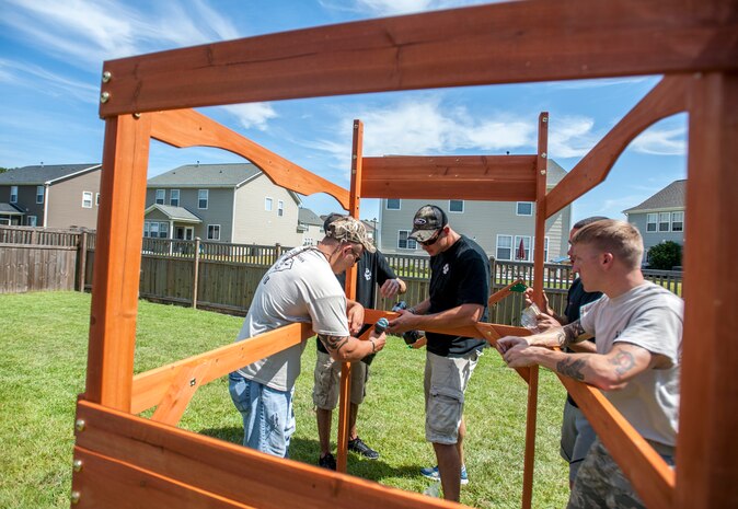 Military working dog handlers from the 628th Security Forces Squadron build a swing set for a deployed Wingman’s daughter Sept. 6, 2013. Staff Sgt. Kyle Shaughnessy, 628th SFS MWD handler, is currently deployed to Southwest Asia. His fellow Airmen built the swing set in accordance with the Trident United Way’s Day of Caring events occurring throughout Joint Base Charleston, where approximately 2,500 servicemembers from the base participated, volunteering their skills to assist with more than 50 projects in the local community. The base held their volunteer events a week earlier than Trident United Way's Day of Caring, due to operational commitments including  the delivery of the final U.S. Air Force C-17 Globemaster III. (U.S. Air Force Photo / Senior Airman Tom Brading)