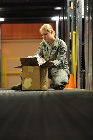 U.S. Air Force Senior Airman Sarah Pearson, 509th Logistics Readiness Squadron aircraft parts journeyman, looks for a stock number on a piece of equipment in the aircraft part store at Whiteman Air Force Base, Mo., Aug. 2, 2013. Without the stock numbers of equipment, Airmen may find it difficult to keep accountability of parts when using their online spreadsheet. (U.S. Air Force photo by Staff Sgt. Nick Wilson/Released)