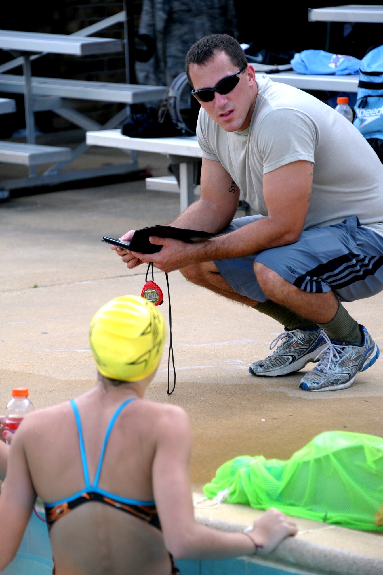 Airman 1st Class Lance Thornton discusses times with a member of his team practice Aug. 30. Thornton began volunteering and sharing his experience from competing at the college level in the 100-yard butterfly, 100-yard breaststroke, 50-yard freestyle, and 200-yard individual medley which he set the school record in 2009. (U.S. Air Force photo by Airman 1st Class William Blankenship)