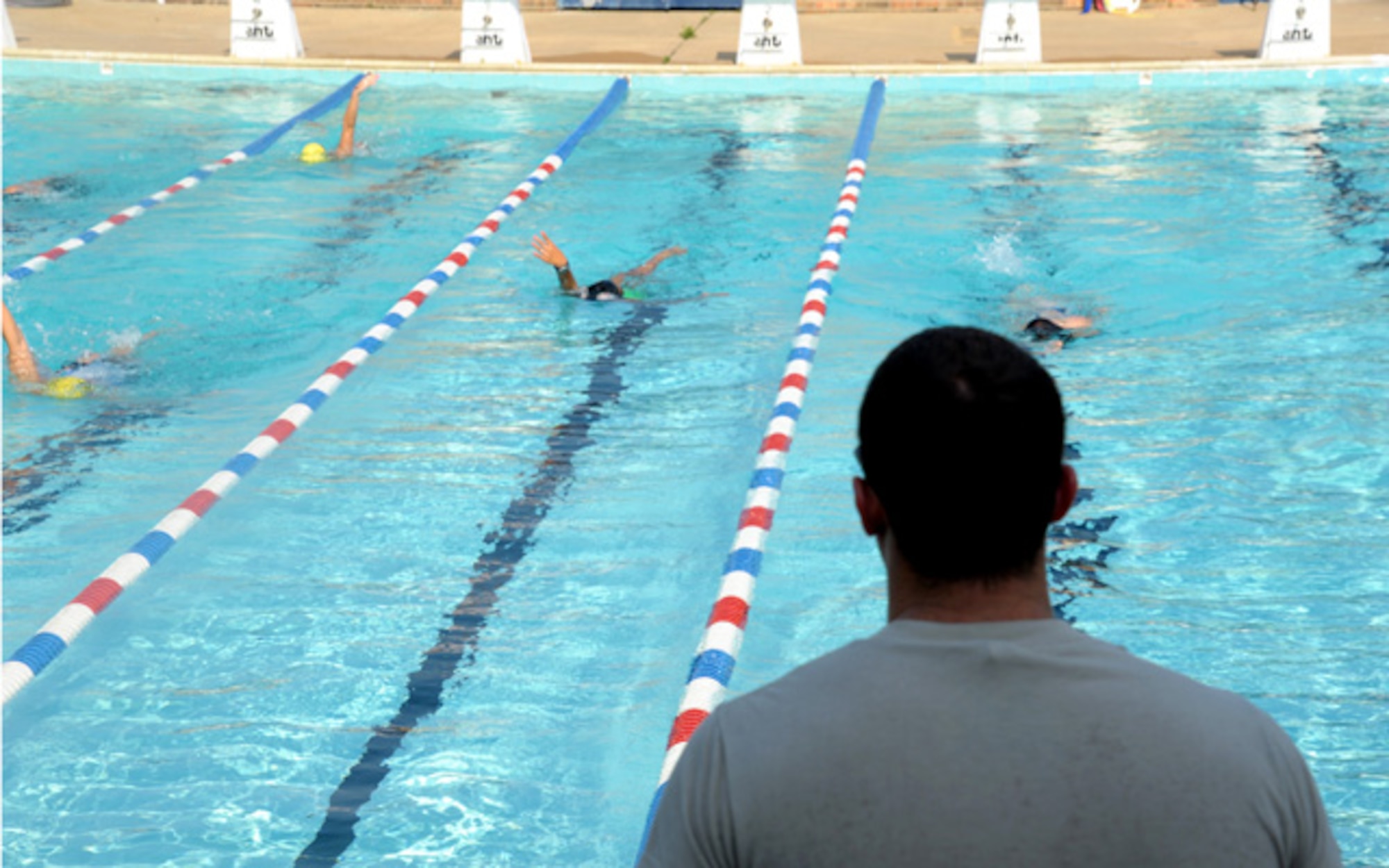 Airman 1st Class Lance Thornton watches his team swim laps at practice Aug. 30. After six months of volunteering with the Montgomery YMCA Barracudas, Thornton became the head coach for the entire program. In this role, Thornton leads the instruction of all of 130 six to 18 year-old swimmers.  (U.S. Air Force photo by Airman 1st Class William Blankenship)