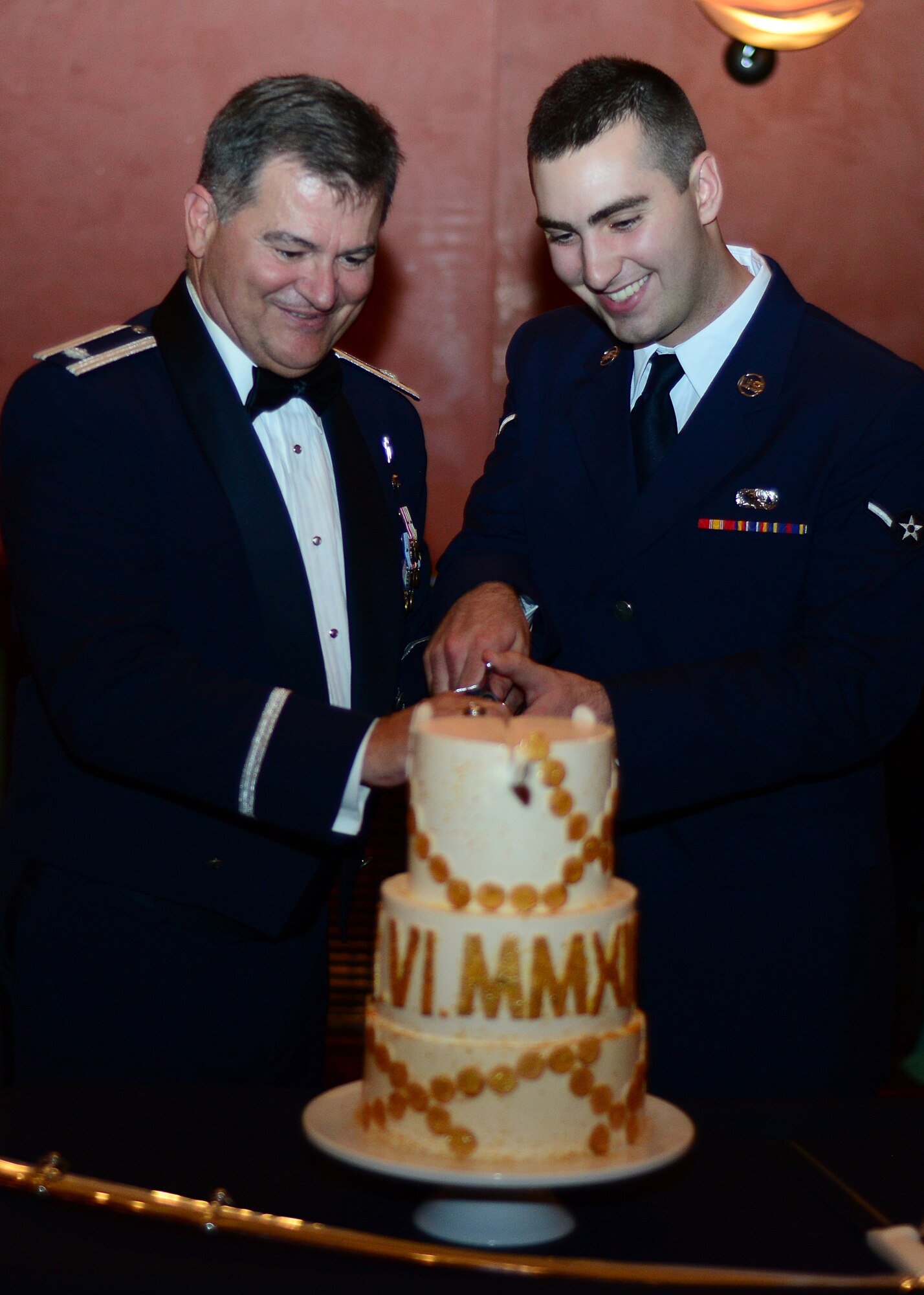 (Left) Lt. Col. John Tillery, 31st Fighter Wing chaplain and Amn. Ryan Conroy, 31st FW photojournalist, cut the birthday cake at the Aviano Air Force Ball Sept. 6, 2013, at Aviano Air Base, Italy. The cutting and sharing of the cake symbolizes the wisdom of the older service members being passed down to the new generation of Airman. This is the 66th Anniversary of the U.S. Air Force. (U.S. Air Force photo/Senior Airman Michael Battles) 