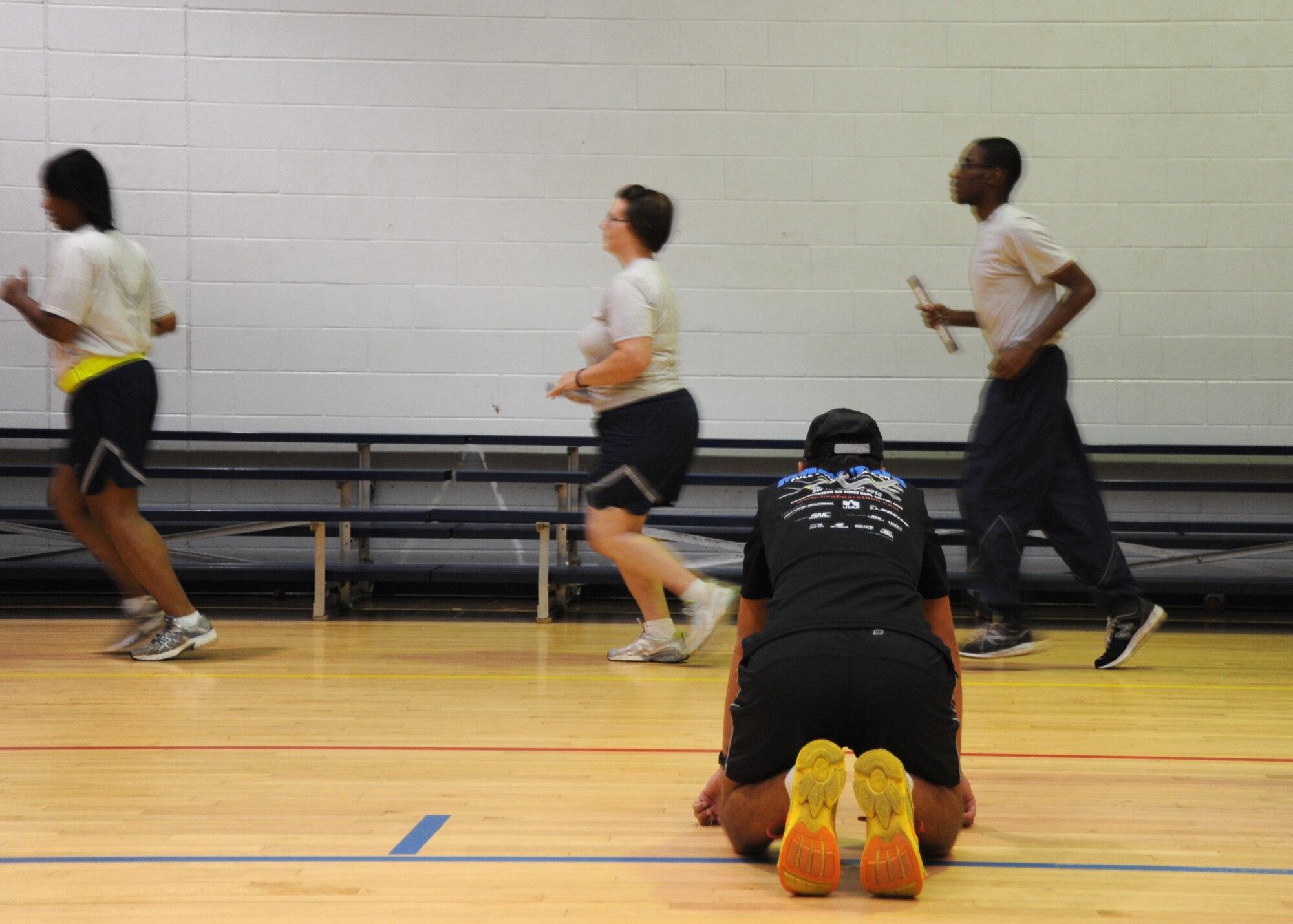 Dr. (Lt. Col.) Antonio Eppolito examines the gait of runners as they pass before him during an Efficient Running Course in the Hercules Gym at Pope Field, N.C., on Sept. 8, 2013. Eppolito gave a two-hour workshop on Efficient Running to 80 members of the 440th Airlift Wing, which consisted of a one-hour presentation and an hour of shoes-off demonstration and exercise.The 440th Airlift Wing is currently training for worldwide deployment. (U.S. Air Force photo by Tech. Sgt. Peter R. Miller)