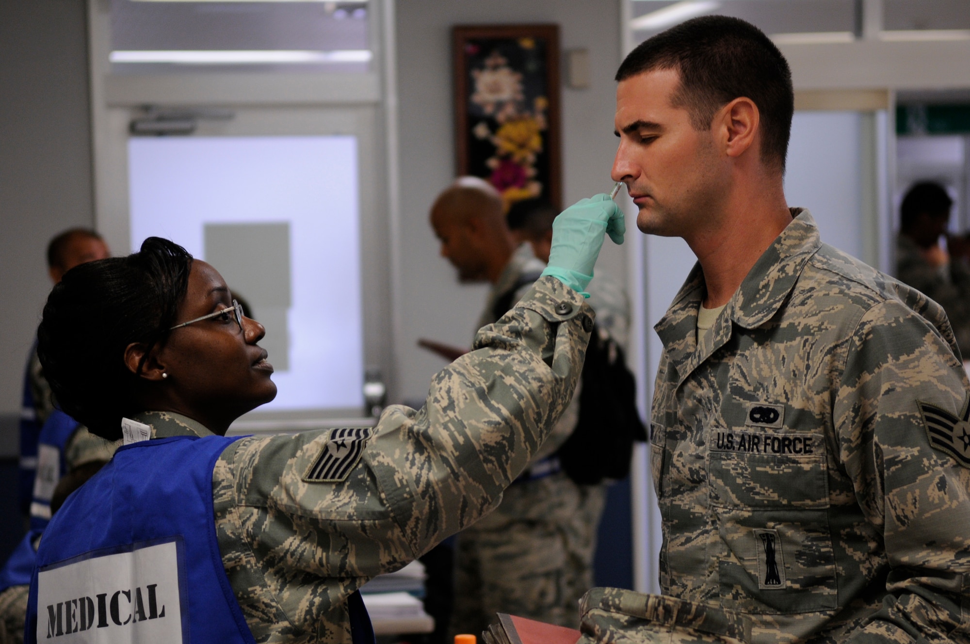U.S. Air Force Tech. Sgt. Maxine Steed, 18th Medical Group allergy immunization specialist, gives an Airman processing through a mock deployment line vaccine during a local operational readiness exercise on Kadena Air Base, Japan, Sept. 10, 2013. LOREs are conducted to test the base's ability to receive and deploy Airmen rapidly to support real world contingencies. (U.S. Air Force photo by Senior Airman Marcus Morris)  