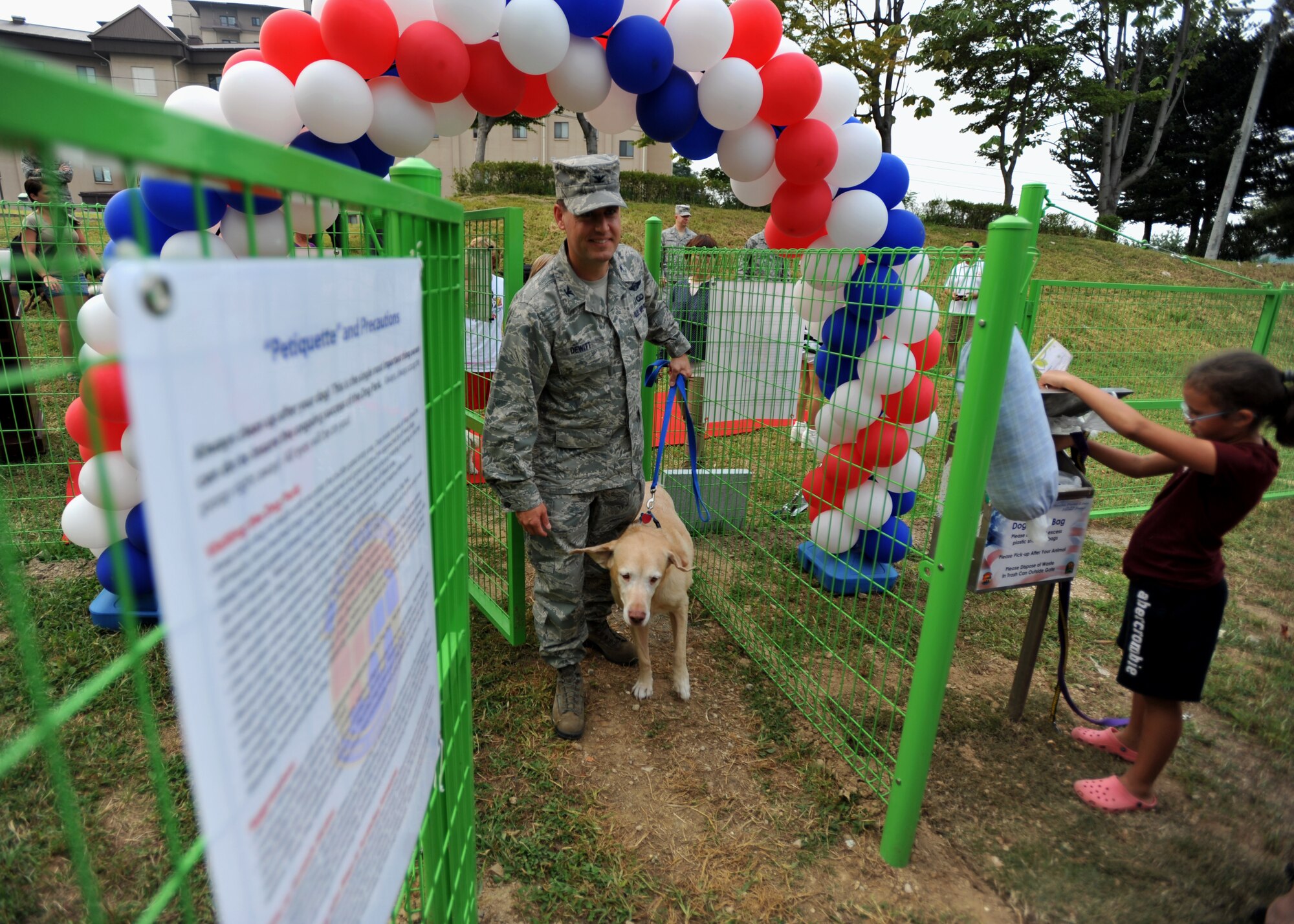 Col. Sean DeWitt, 51st Fighter Wing vice commander, walks his dog into the newly opened dog park during its grand opening at Osan Air Base, Republic of Korea, Sept. 9, 2013. The dog park is now open to all Team Osan dogs and their owners. (U.S. Air Force photo/ Senior Airman Siuta B. Ika)