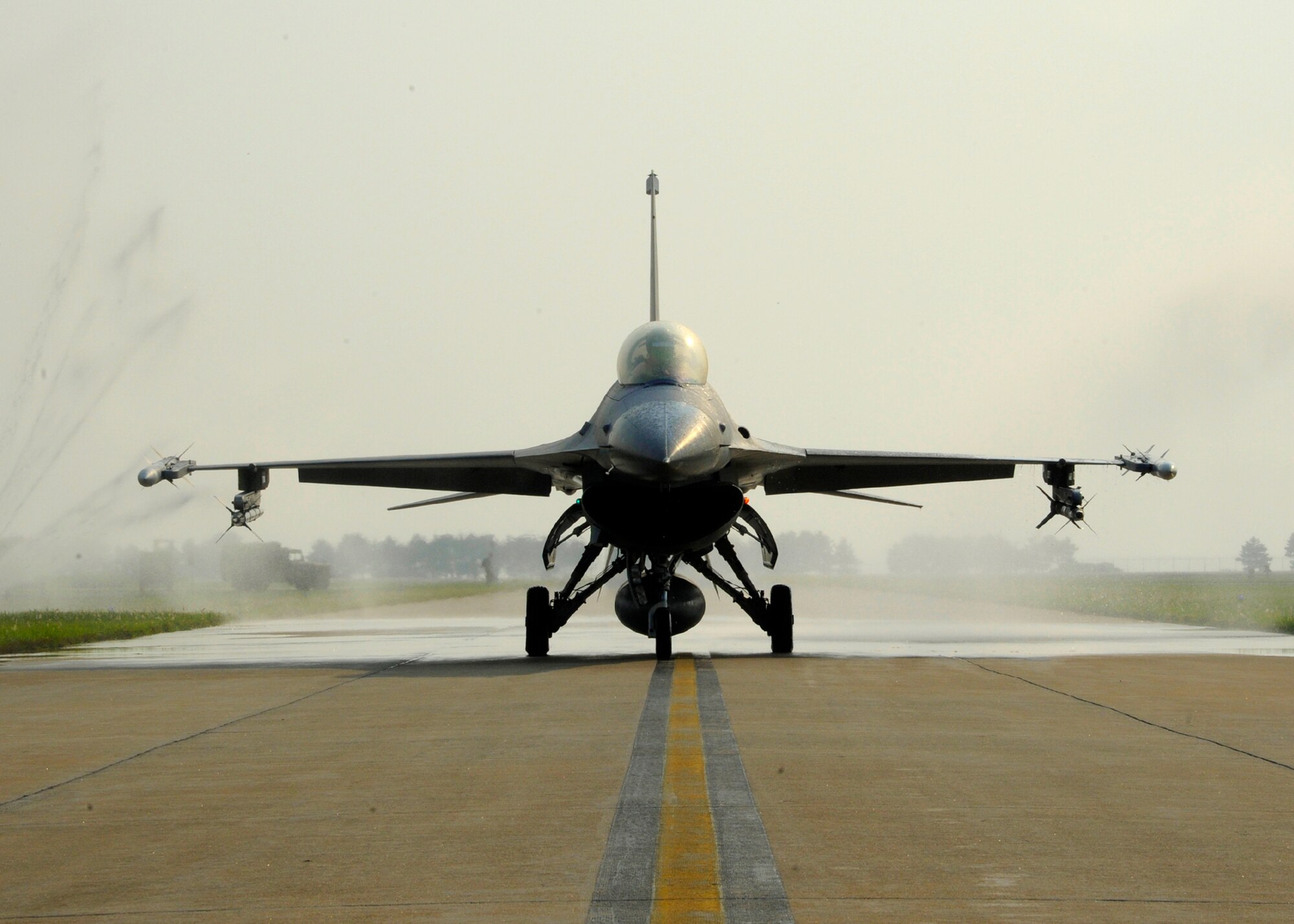 An F-16 Fighting Falcon from the 8th Fighter Wing taxies through a ‘bird bath’ at Kunsan Air Base, Republic of Korea, Aug. 28, 2013. ‘Bathing the birds’, ensure the jets stay in good working order and free from corrosion. (U.S. Air Force photo by Staff Sgt. Jessica Haas/Released)