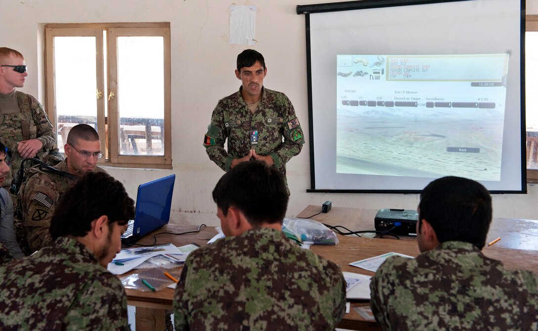 U.S. soldiers observe as an Afghan army fire support officer teaches a class on the D-30 122mm howitzer on Forward Operating Base Tagab in Kapisa province, Afghanistan, Sept. 3, 2013.