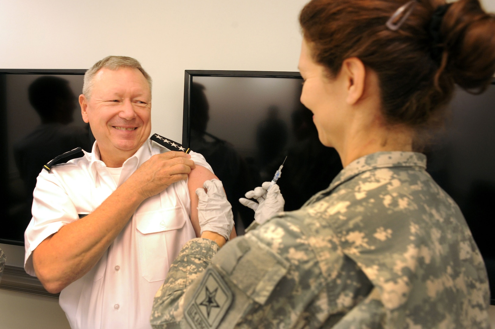 Army Gen. Frank J. Grass, chief, National Guard Bureau, receives a flu vaccination at the Pentagon from Army Maj. Laurie Fontaine, a physicians assistant and medical standards officer with the Army National Guard Office of the Surgeon General, Monday, Sept. 24, 2012. The flu vaccine --which is mandatory for servicemembers to receive -- is one way servicemembers can remain healthy during the coming flu and cold season.