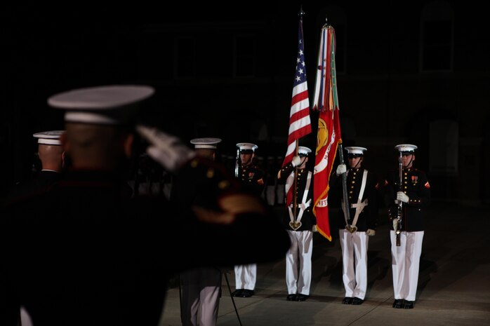 The Marines of the 8th and I Evening Parade present the colors during the opening, Aug. 23. The 8th and I Marines as well as any active-duty service members in the crowd salute the colors as a form of respect to the Marine Corps and the nation. 