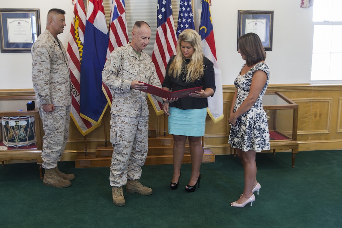 Col. James W. Clark, the deputy commander of Marine Corps Installations East, awards Sarah Dodson, left, and Clarissa McAllister Certificates of Commendation aboard Marine Corps Base Camp Lejeune, Sept. 5. They received the awards for rescuing and resuscitating a two-year-old from the Bicentennial Community Center Pool aboard base, July 2. “I’m just happy to see her healthy and back with her family,” said Dodson.