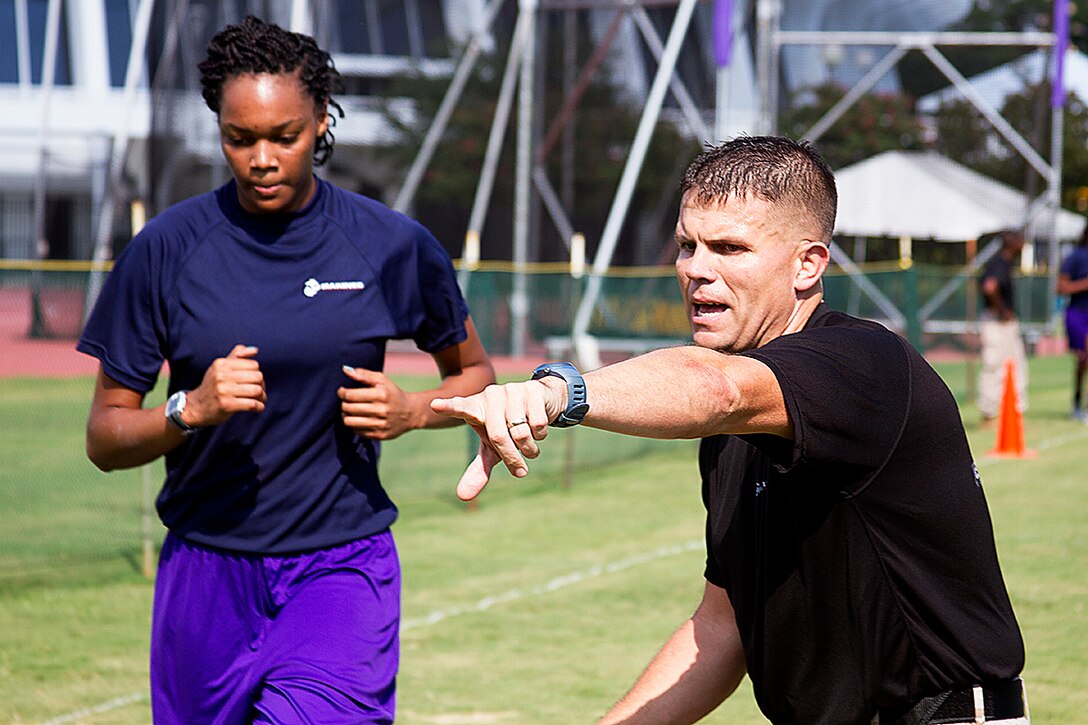 Gunnery Sgt. Michael Lawrence, Assistant Recruiter Instructor for Recruiting Station Baton Rouge, motivates one of the players from the Louisiana State University women’s basketball team as she completes the maneuver under fire portion of the combat fitness course next to the track and field at LSU in Baton Rouge, La., Sept. 9, 2013. Marines from Officer Selection Team Baton Rouge, and surrounding area joined together with the women’s basketball team from LSU to complete a combat fitness course not just once, but twice, helping them push themselves to a higher limit, setting the bar above other colleges. The event instilled in the athletes Marine Corps leadership values and teamwork that the players can use both on and off the court. (U.S. Marine Corps photo by Lance Cpl. John-Paul Imbody)