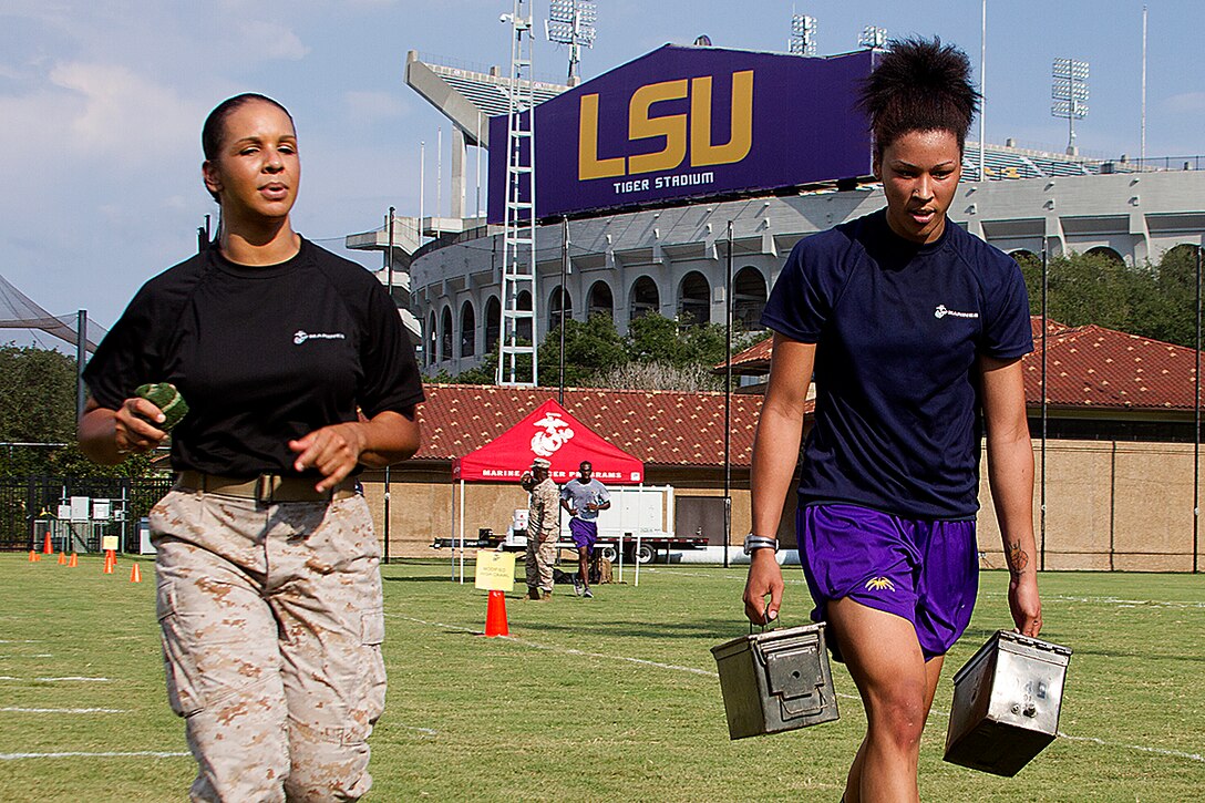 Capt. Ashley Ferninand, Adjutant for Forces Headquarters Group, Marine Corps Reserve, motivates one of the players from the Louisiana State University women’s basketball team as she completes the maneuver under fire portion of the combat fitness course next to the track and field at LSU in Baton Rouge, La., Sept. 9, 2013. Marines from Officer Selection Team Baton Rouge, and surrounding area joined together with the women’s basketball team from LSU to complete a combat fitness course not just once, but twice, helping them push themselves to a higher limit, setting the bar above other colleges. The event instilled in the athletes Marine Corps leadership values and teamwork that can be used both on and off the court. (U.S. Marine Corps photo by Lance Cpl. John-Paul Imbody