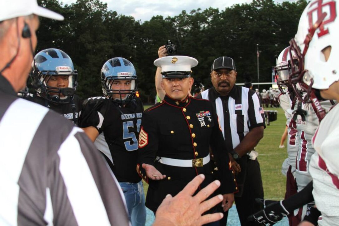 U.S. Marine Corps Staff Sgt. Jefferson Brink, a canvassing recruiter from Recruiting Substation Richmond South and native of Eureka, Calif., prepares to flip the coin in the pre-game coin toss for the Great American Rivalry Series football game of L.C. Bird vs. Thomas Dale high schools Sept. 6, 2013. The two schools are only a few miles apart, and the rivalry is known locally as "The Battle of Chesterfield." RS Richmond sponsored the long-standing rivalry game as part of the Great American Rivalry Series, taking place this year at the Skyhawks' stadium in Chesterfield, Va. The defending state champion Skyhawks defeated the Knights 35-6. (U.S. Marine Corps photo by Cpl. Aaron Diamant/Released)